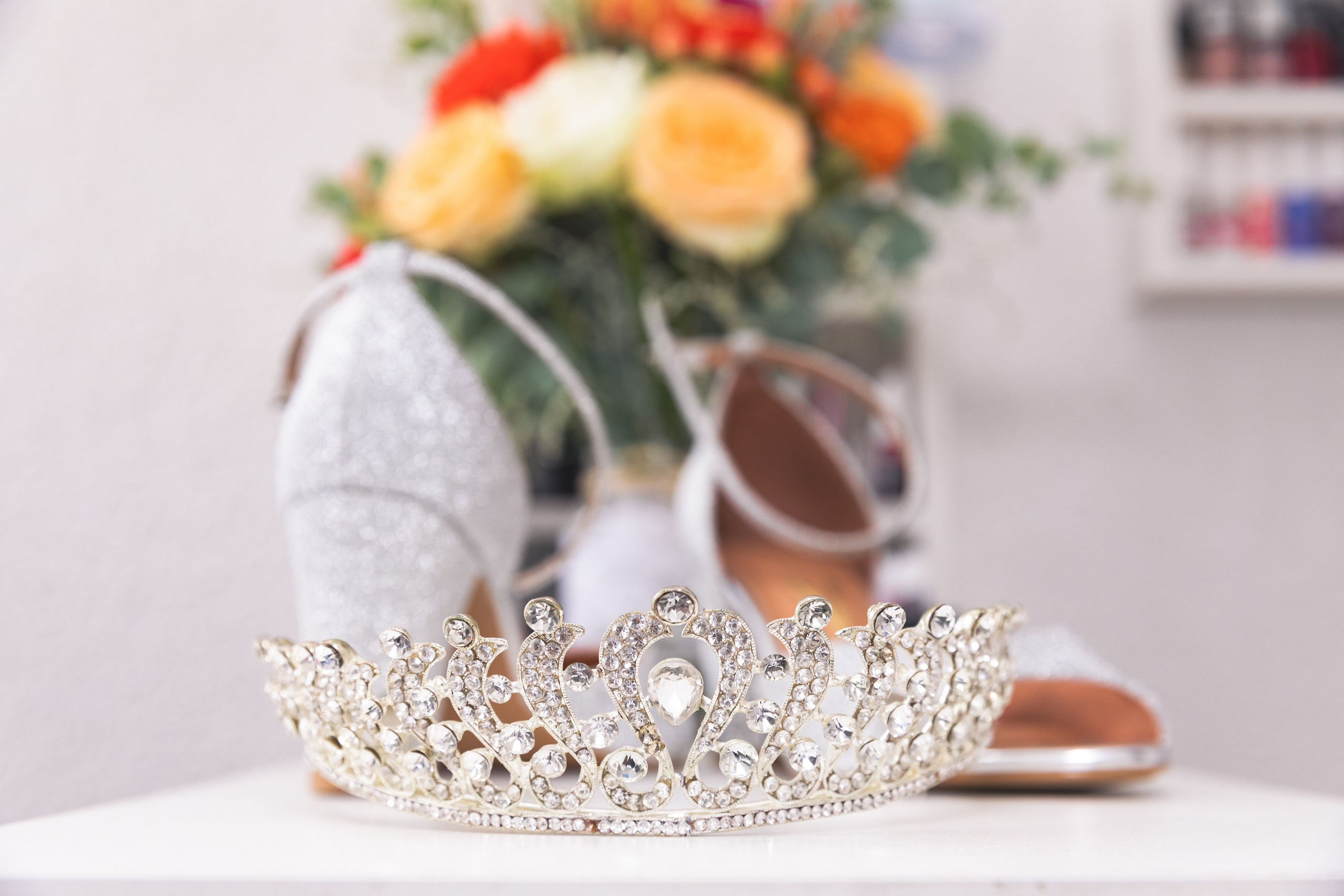 Sapatos da noiva com sua coroa a frente e buquê ao fundo, registro feito em seu making-of, que momento especial