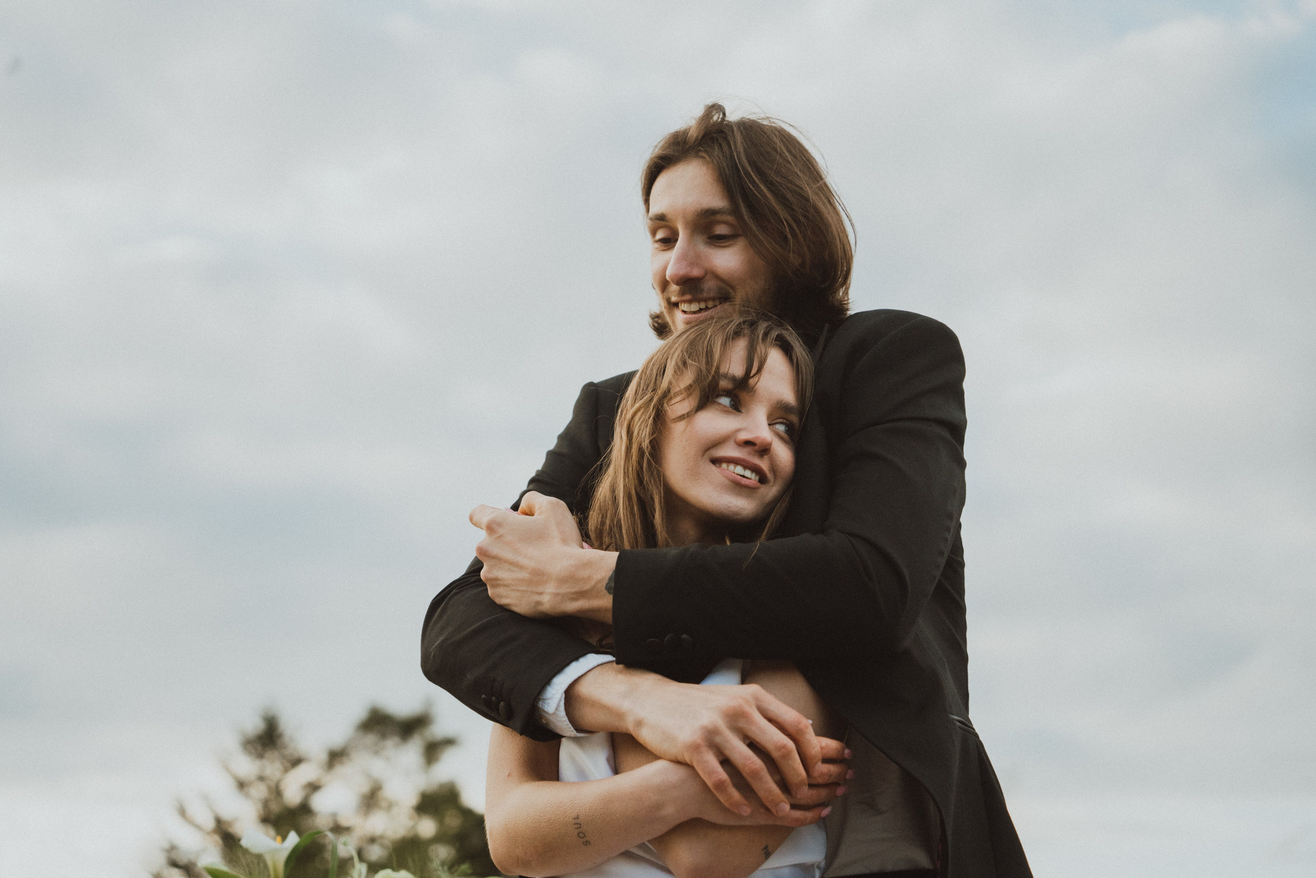 Láska v objetí - nevěsta a ženich zachycení ve chvíli plné něhy a radosti. Přirozený moment, který vystihuje sílu jejich spojení. 
