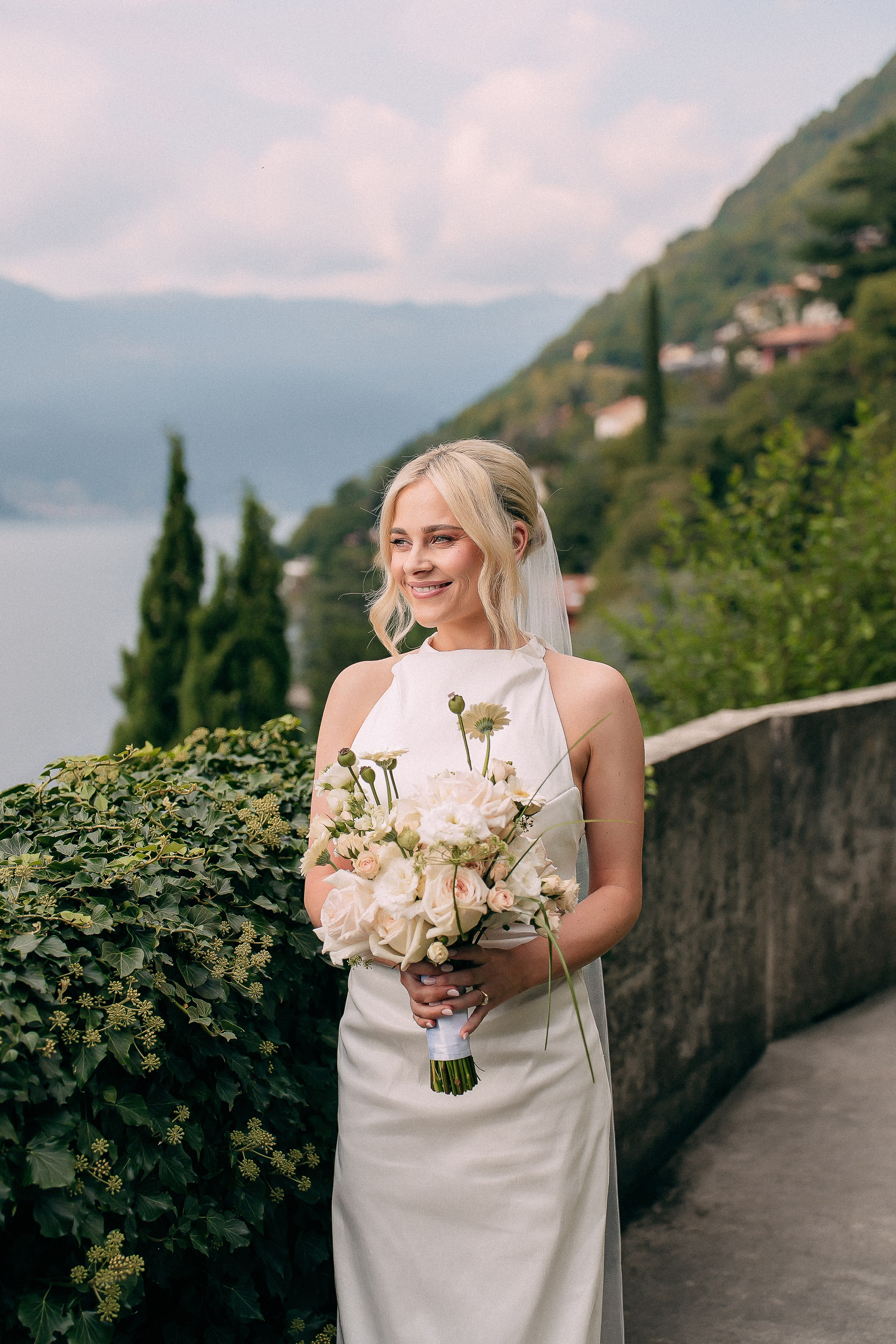 Bride with her bouquet overlooking Lake Como at Villa Lario, Italy