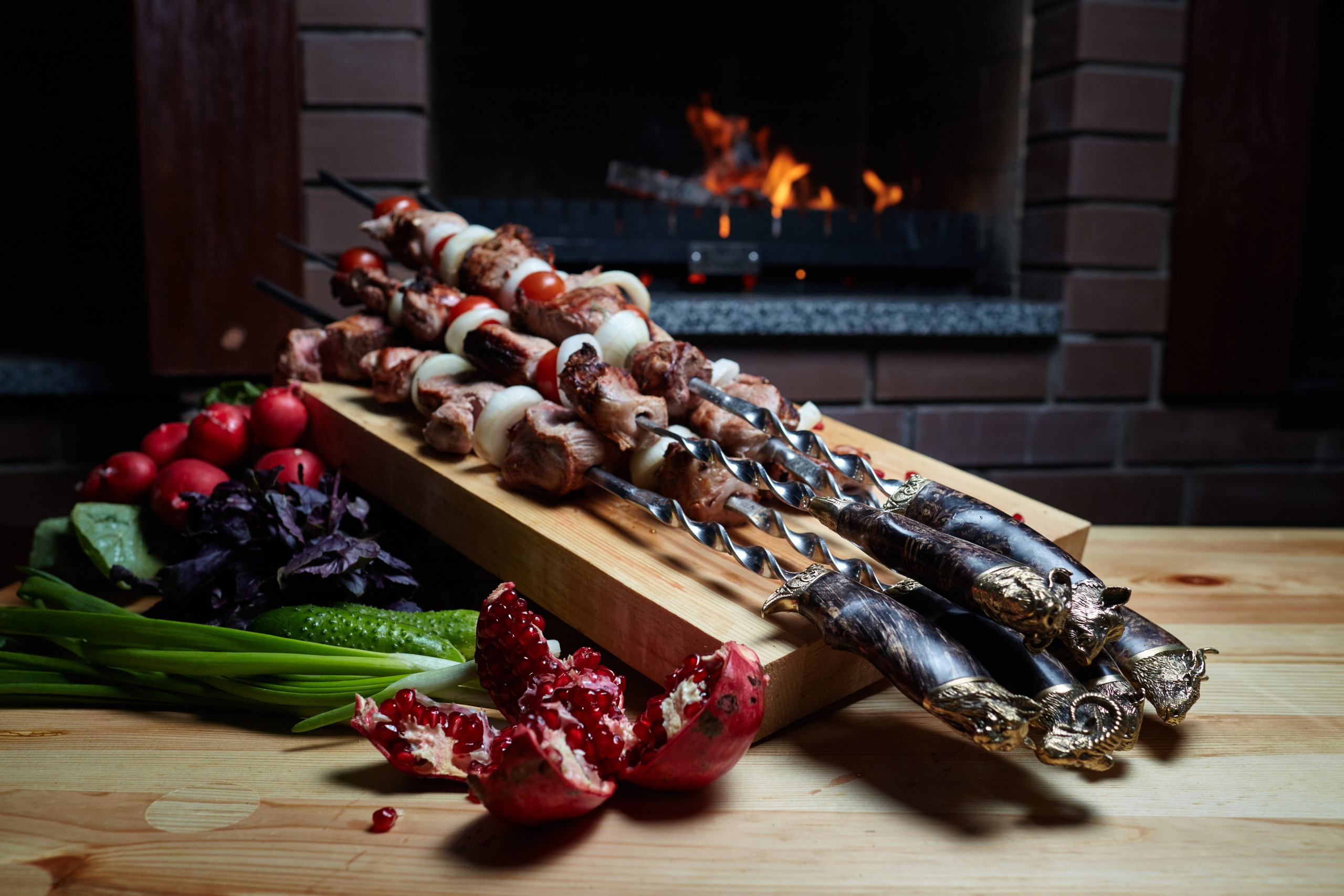 Photographie gastronomique de brochettes au feu de bois avec radis, herbes et ambiance cheminée – photo culinaire en France