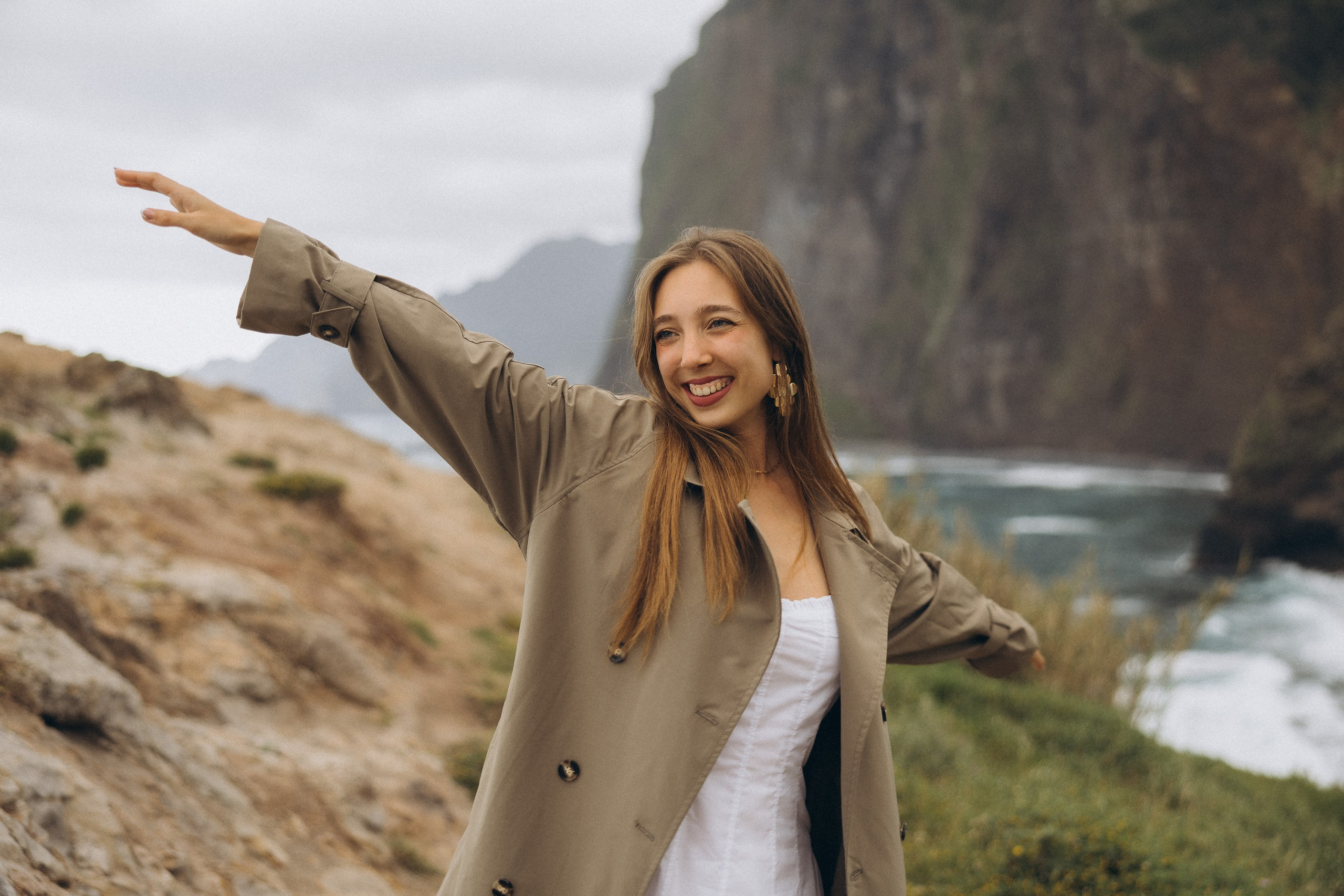 Beautiful engagement moment by the ocean in Madeira, Portugal, as one partner kneels to propose while waves crash in the background.