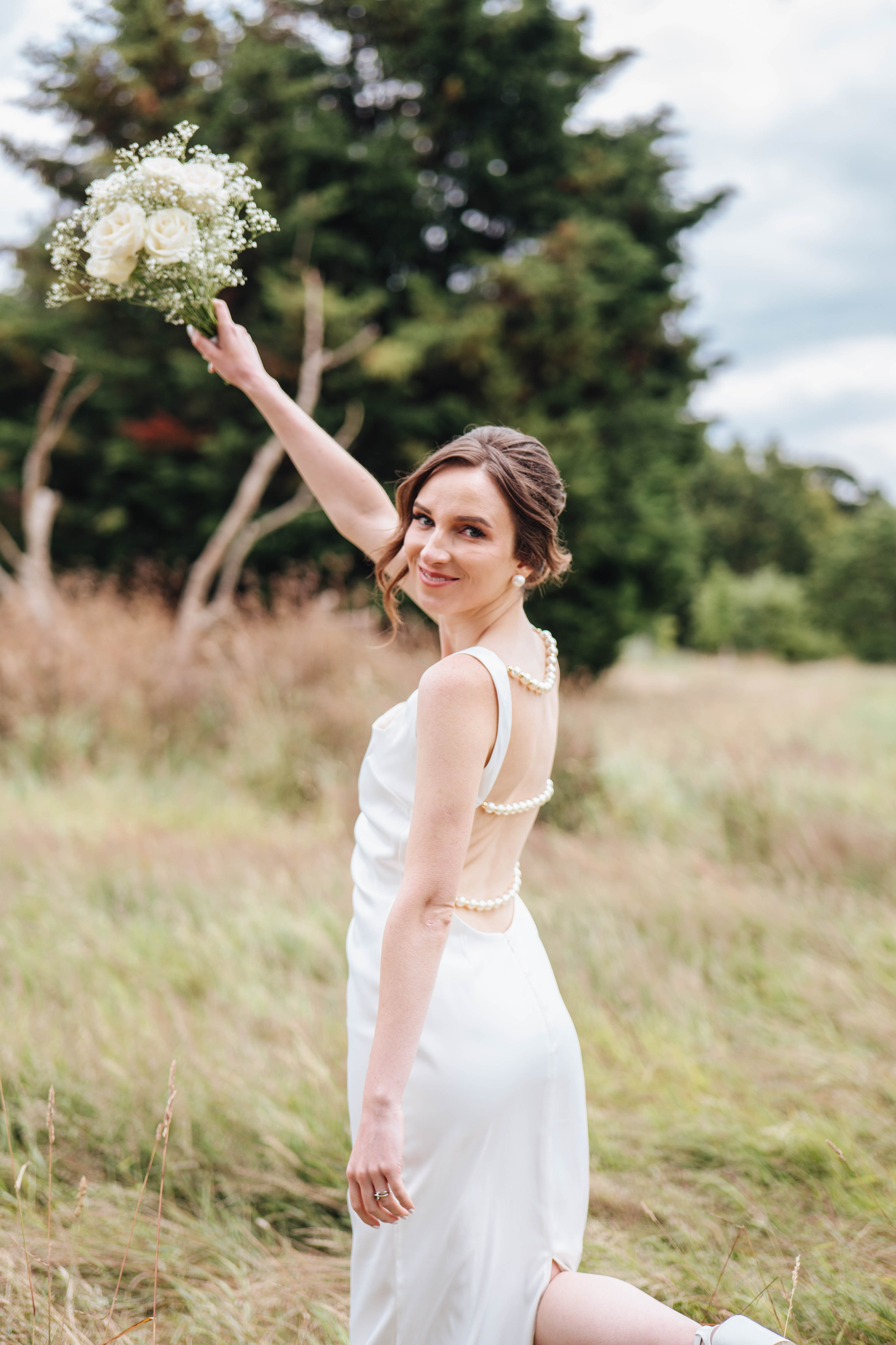 Happy bride holding flowers and smiling at the camera