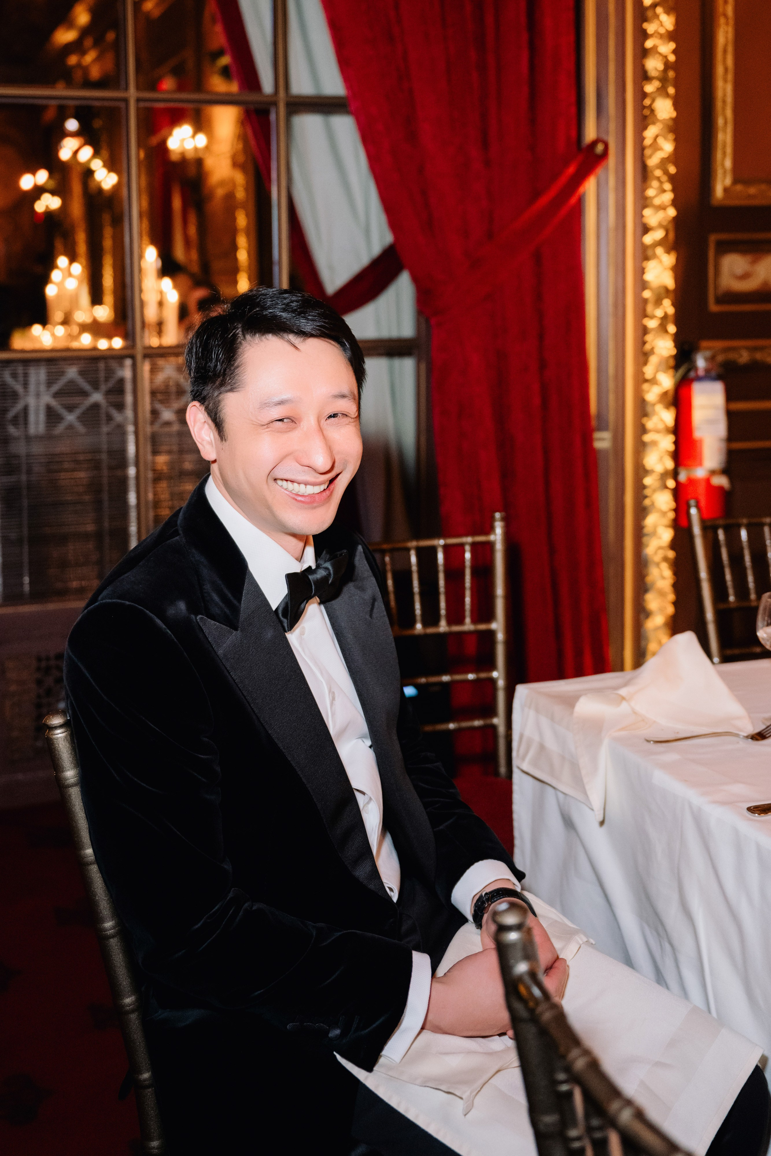 a man in a tuxed suit sitting at a table