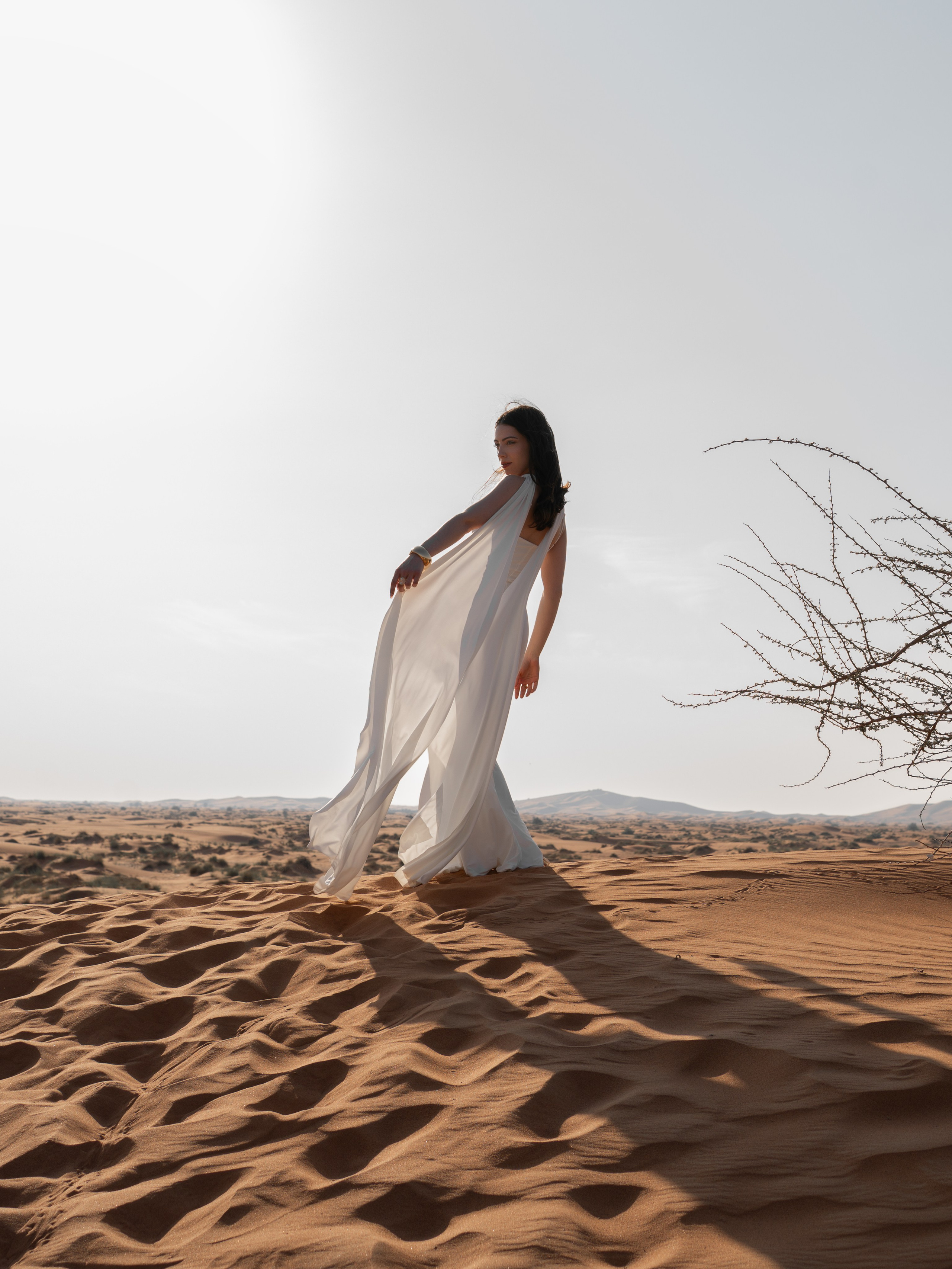 Fashion and femenine style outdoor photoshoot in Dubai desert with a flying white dress by photographer Alisha Geva 