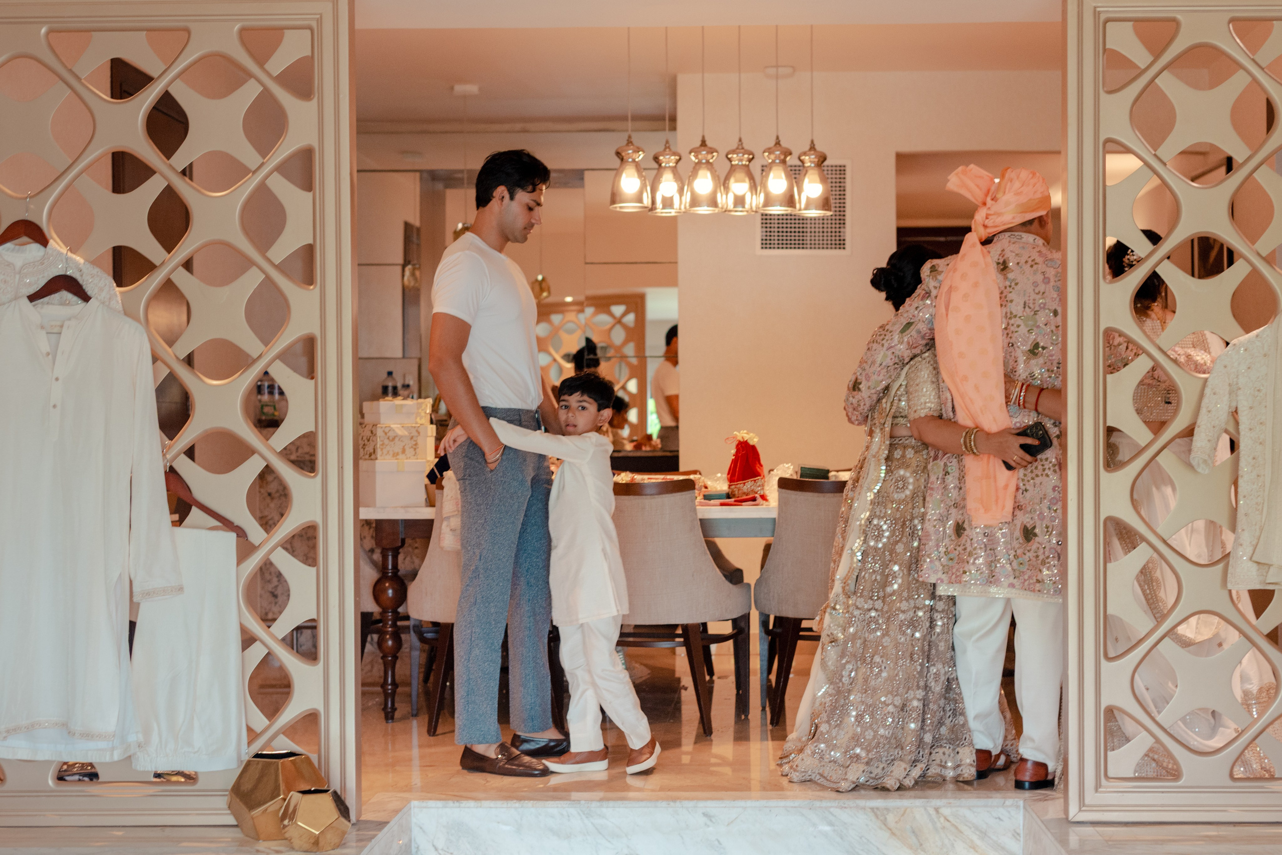 Indian wedding groom embraced by his nephew while surrounded by family during preparation in Cancun Mexico