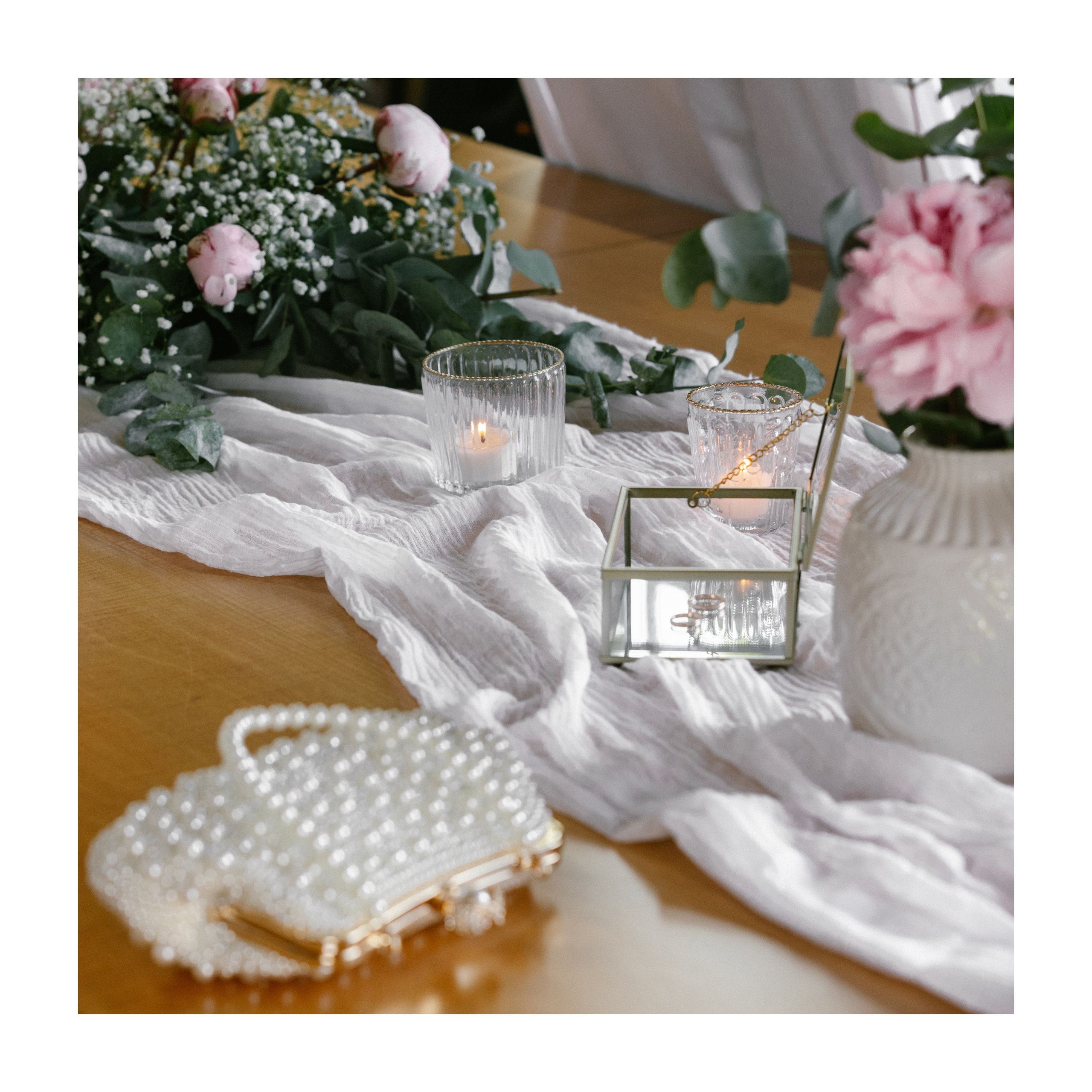 Wedding flatlay with peonies, rings, candles and clutch inside Teehaus at Schloss Meersburg