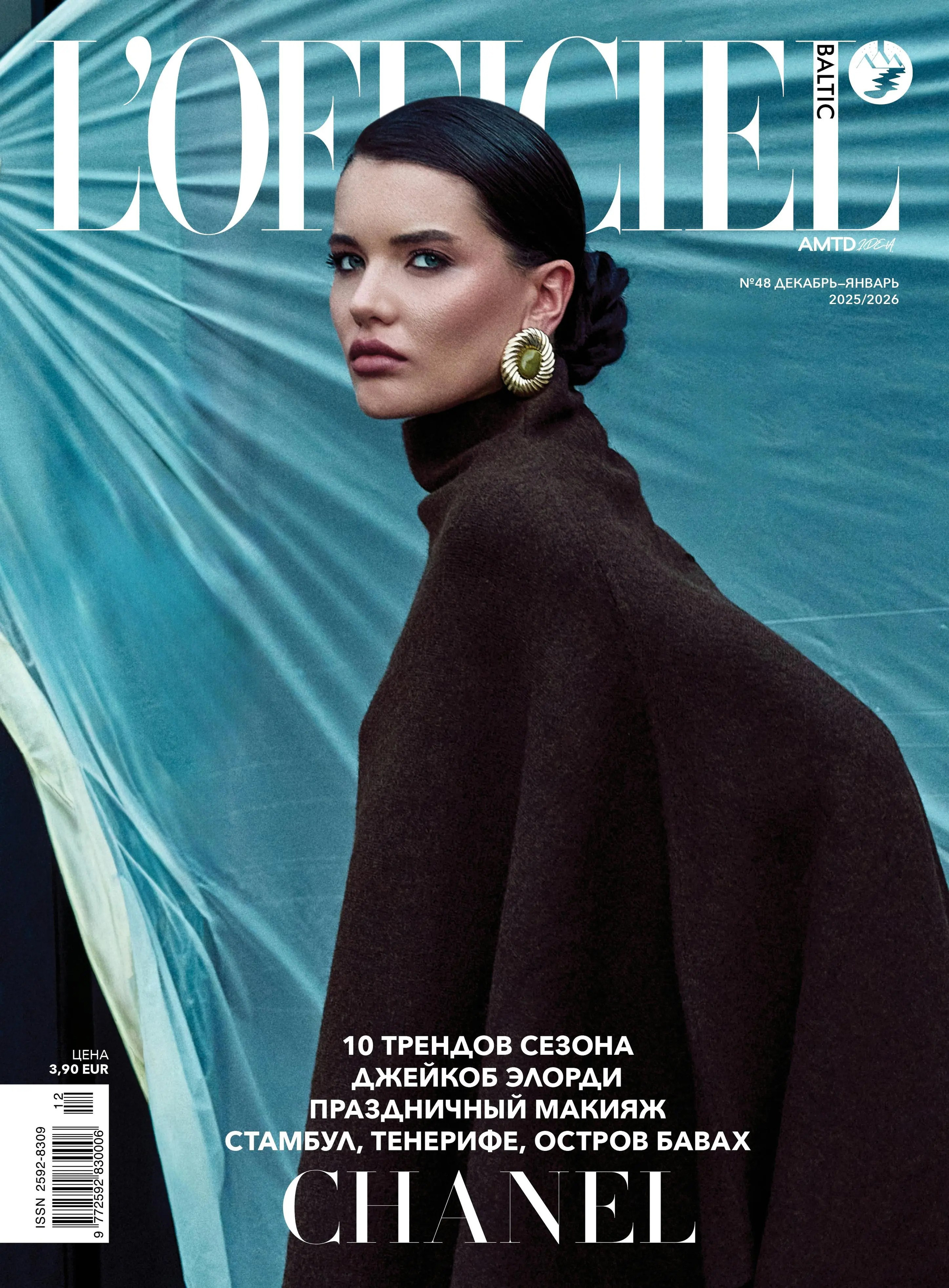 Model in black outfit posing against blue textured background