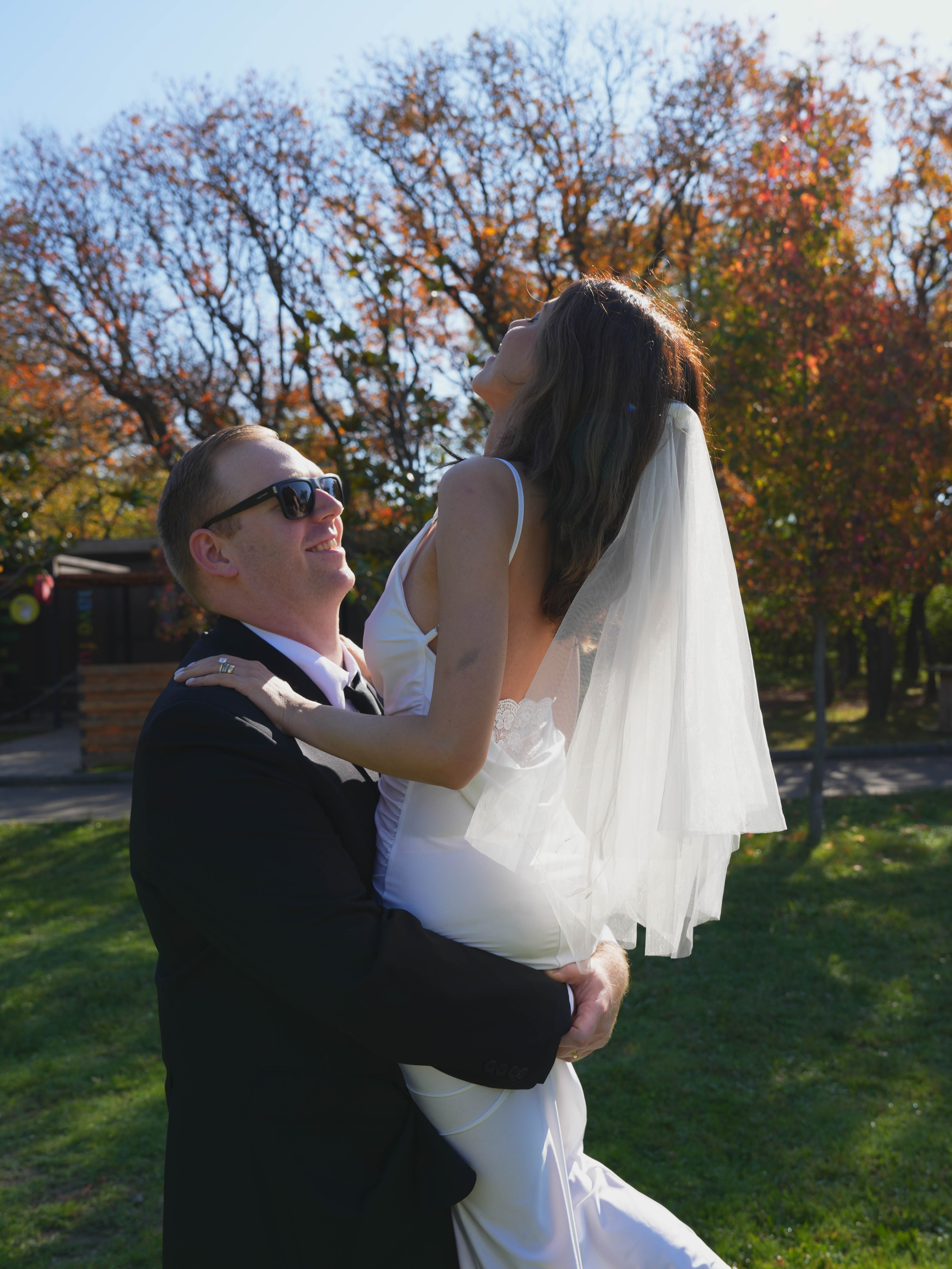Couple dancing by the lake surrounded by golden trees