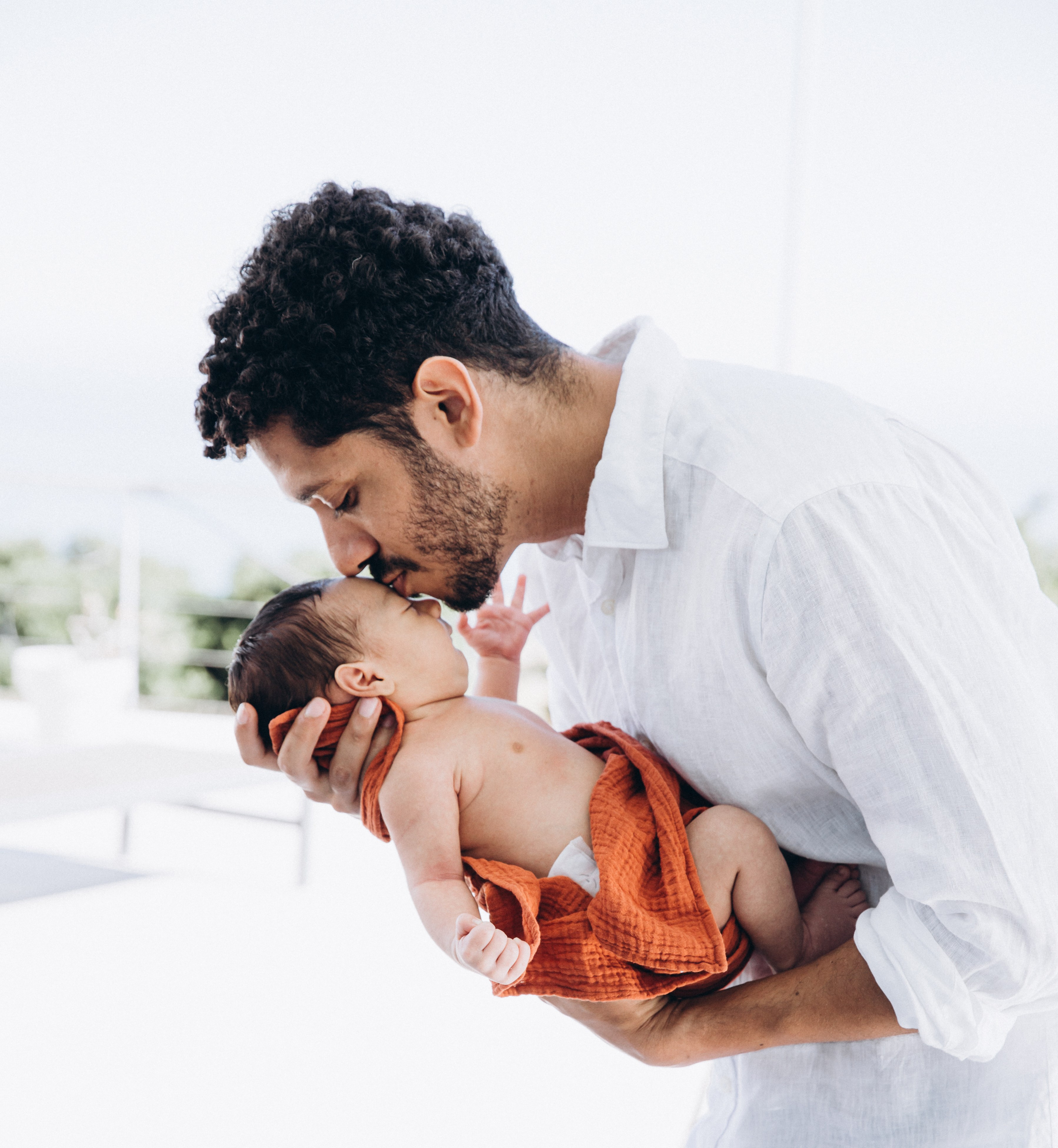 Padre amoroso besando a su recién nacido durante una tranquila sesión de fotos familiar en Cullera, España — capturando emoción pura, conexión y la belleza de la paternidad temprana. Perfecto para quienes buscan sesiones de fotos familiares íntimas y naturales en Cullera y España.