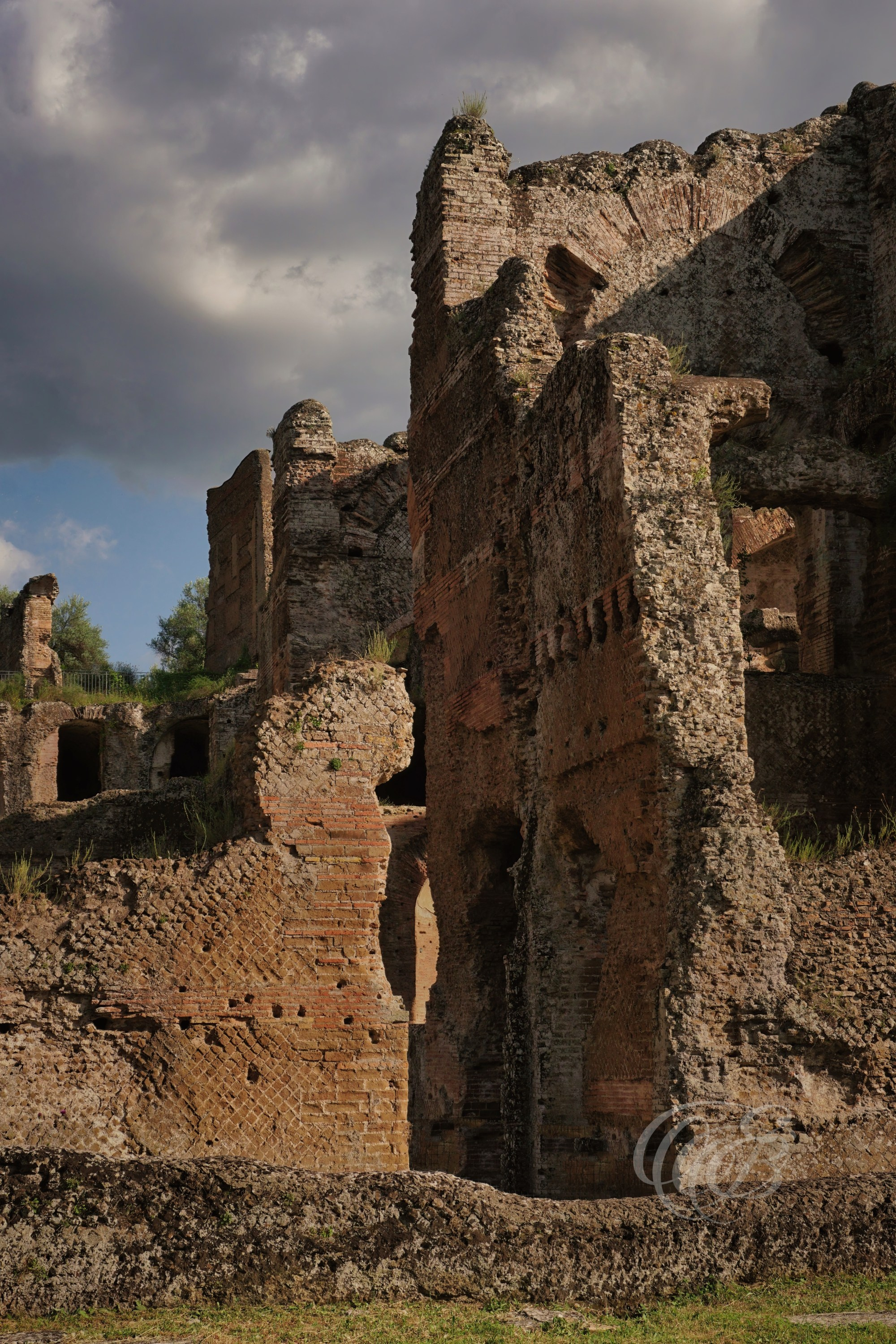 Viewed from the outside, the Great Thermae reveal the monumental scale of one of the largest bathing complexes within Hadrian's Villa. The surviving walls, arches, and brickwork provide a clear impression of the engineering and architectural ambition that characterised the Roman baths.