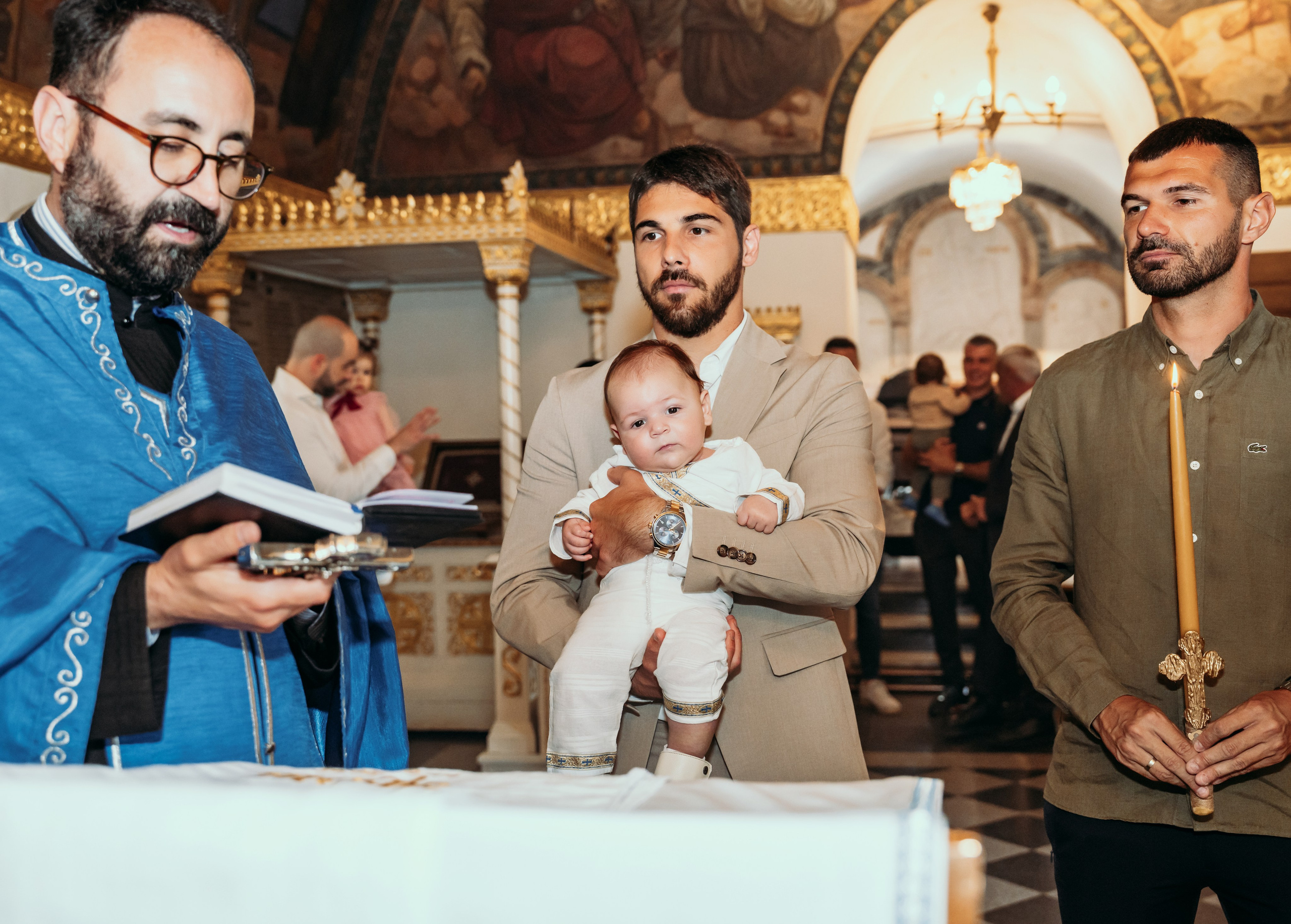 Kum drzi decaka tokom krstenja u starom delu beograda