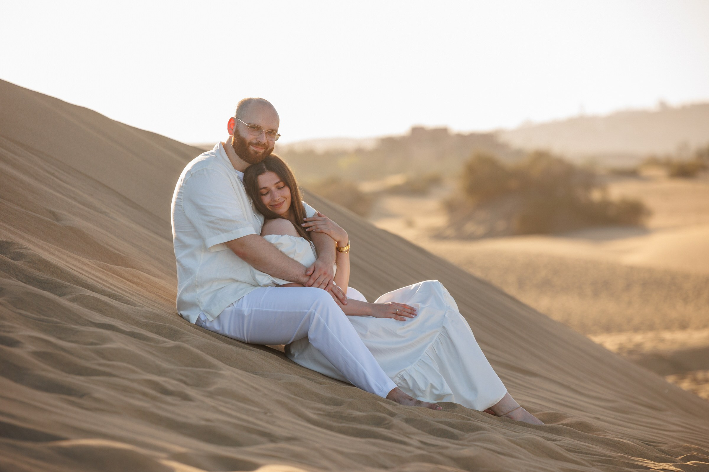 Couple sitting on Maspalomas dunes at golden hour, Gran Canaria
