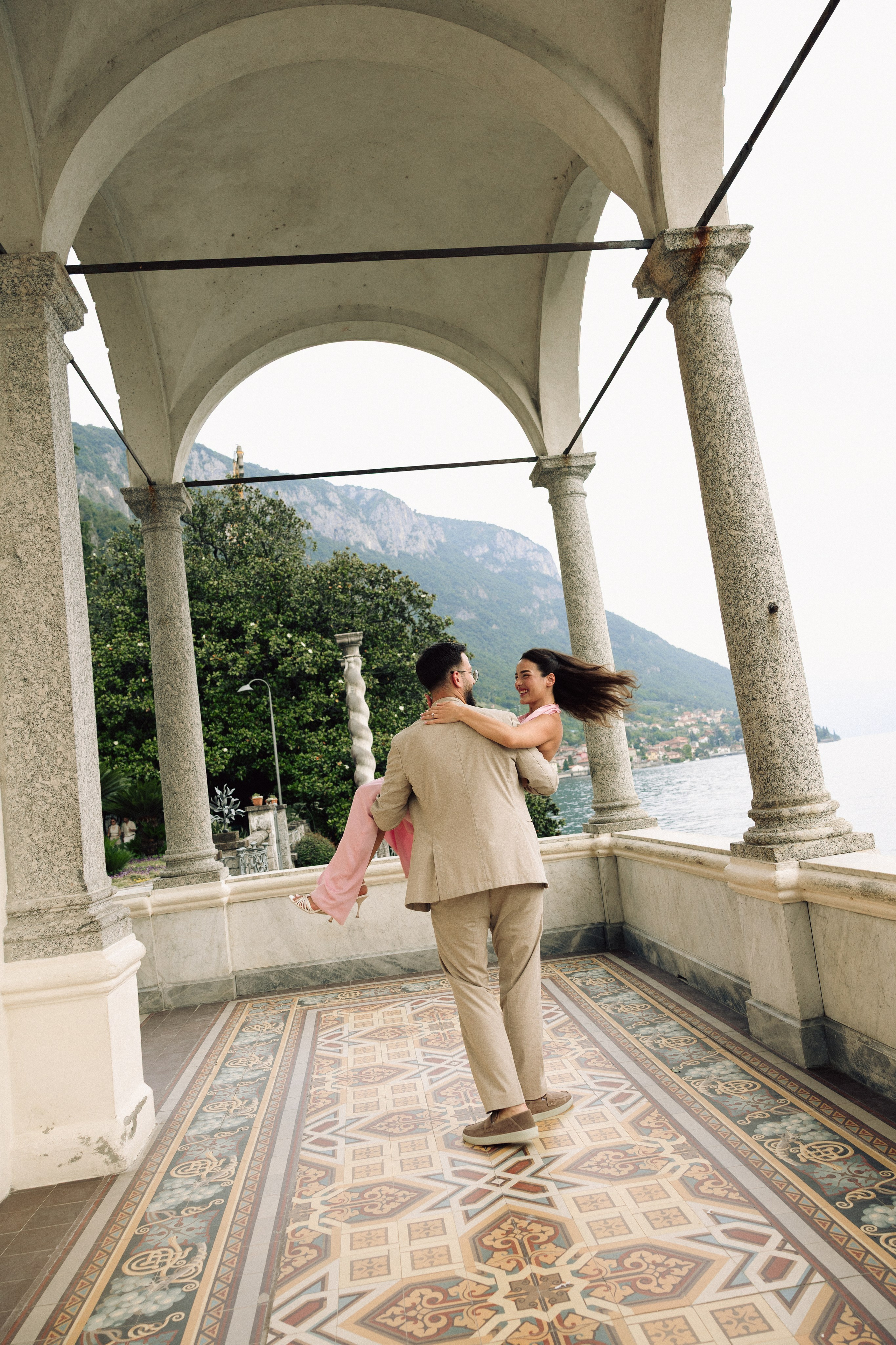 Couple sharing an emotional moment after a surprise proposal in Lake Como, Italy