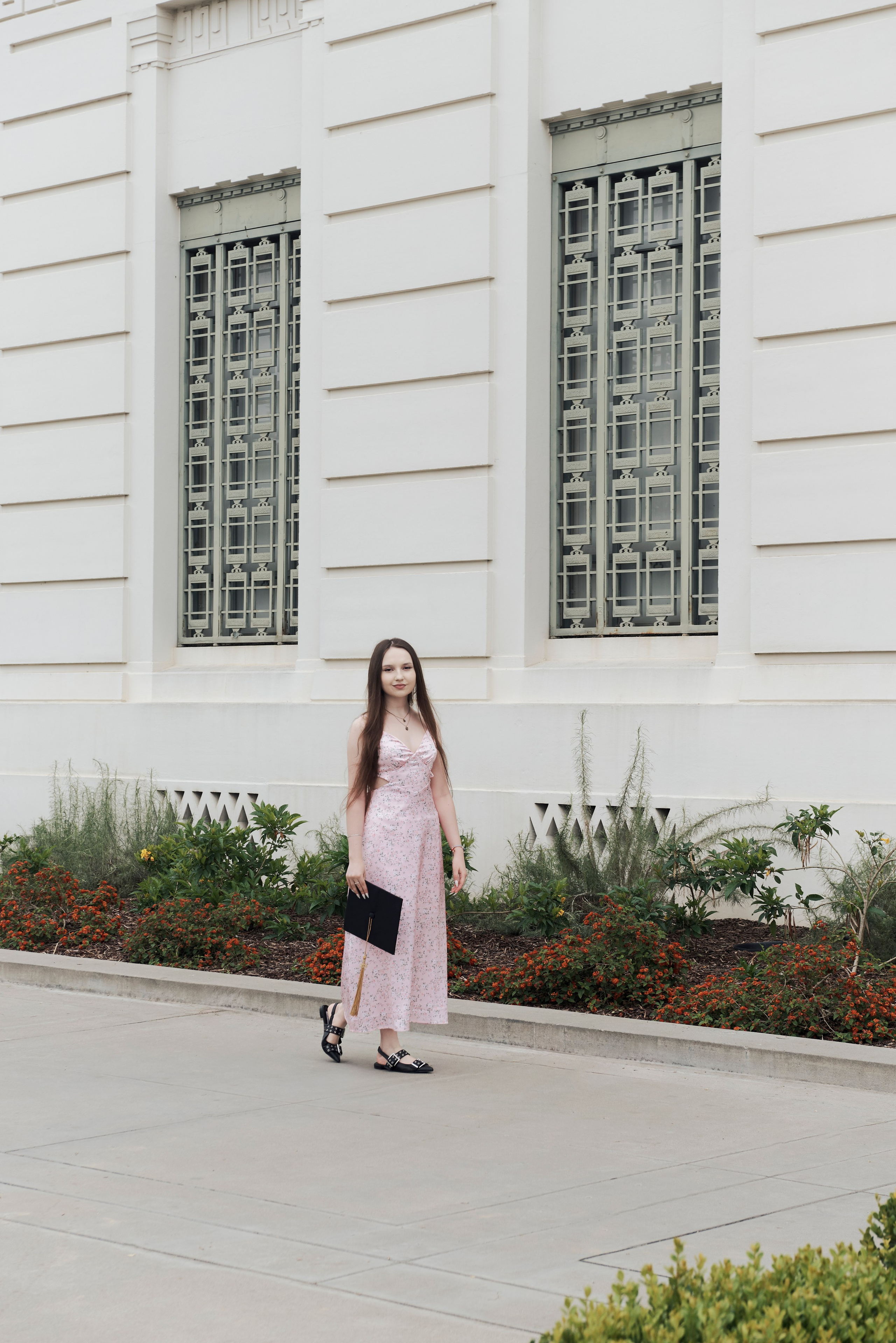 Close-up of a graduate's cap decorated with a personalized message against a LA backdrop