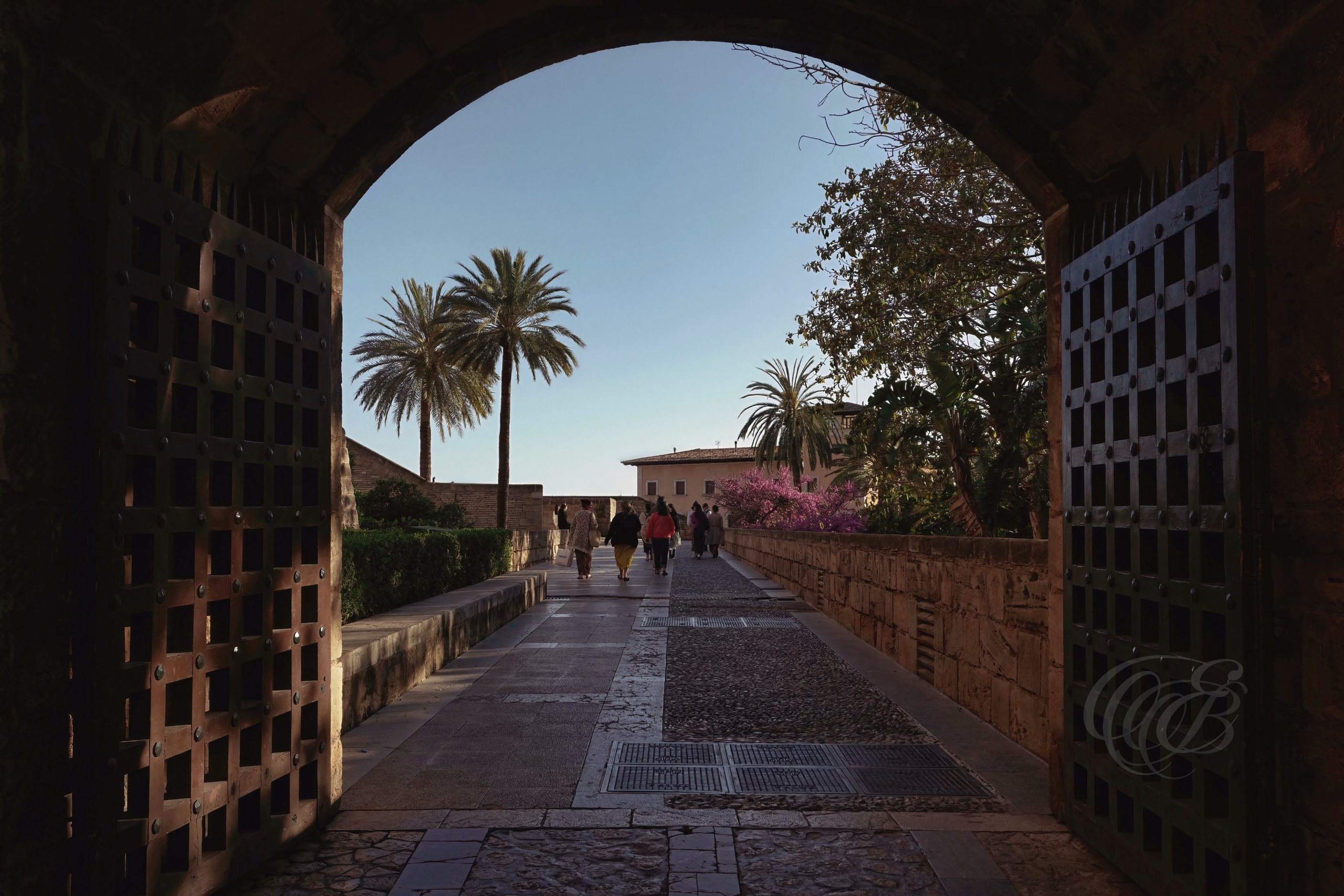The Royal Palace of La Almudaina stands as one of Palma’s most historically significant landmarks, reflecting the layered cultural history of Mallorca from the Islamic period through the Crown of Aragon. Originally constructed as an Arab fortress during Moorish rule, the palace was transformed in the 13th century after the conquest of Mallorca by King James I of Aragon in 1229, later becoming an official royal residence. Its Gothic halls, fortified towers, arches, and medieval courtyards overlook the Bay of Palma beside La Seu Cathedral, forming one of the most iconic architectural ensembles in the Balearic Islands. This view captures the enduring presence and historical character of La Almudaina within the heart of Mallorca’s capital. Eduardo Bartoli Photography.