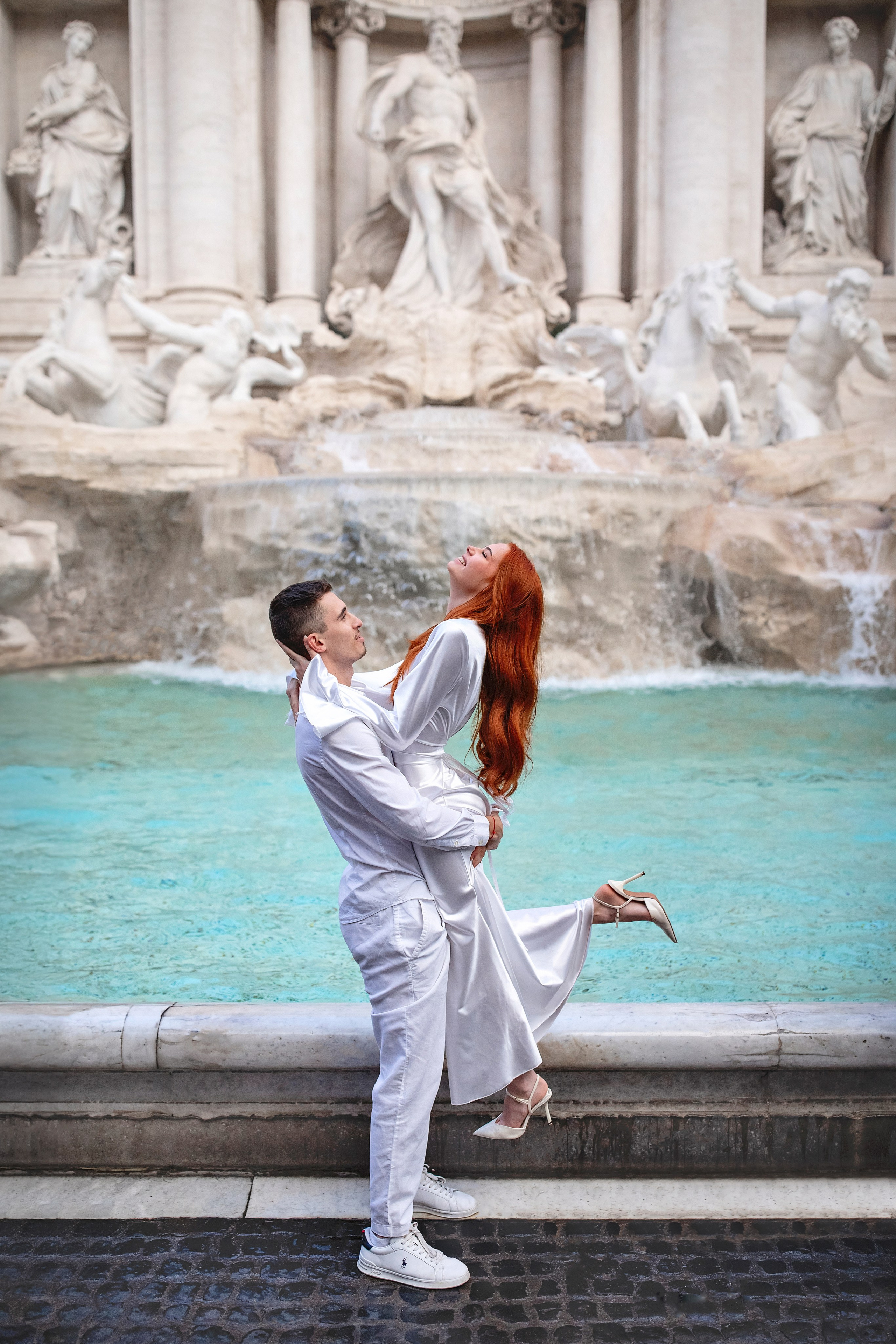 Couple posing at the Trevi Fountain during a romantic photoshoot in Rome