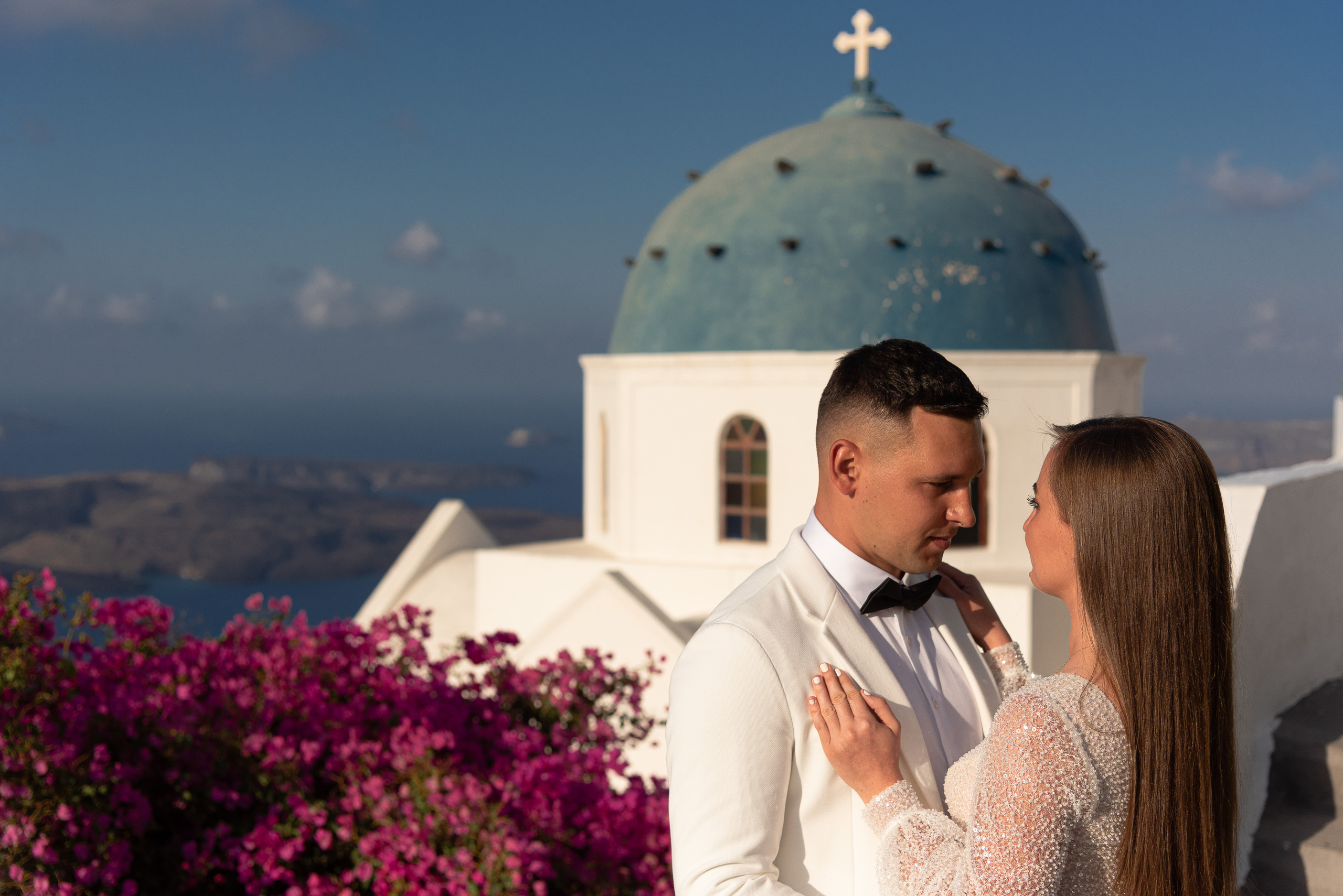 A couple of newlyweds on the background of the blue roofs of Santorini