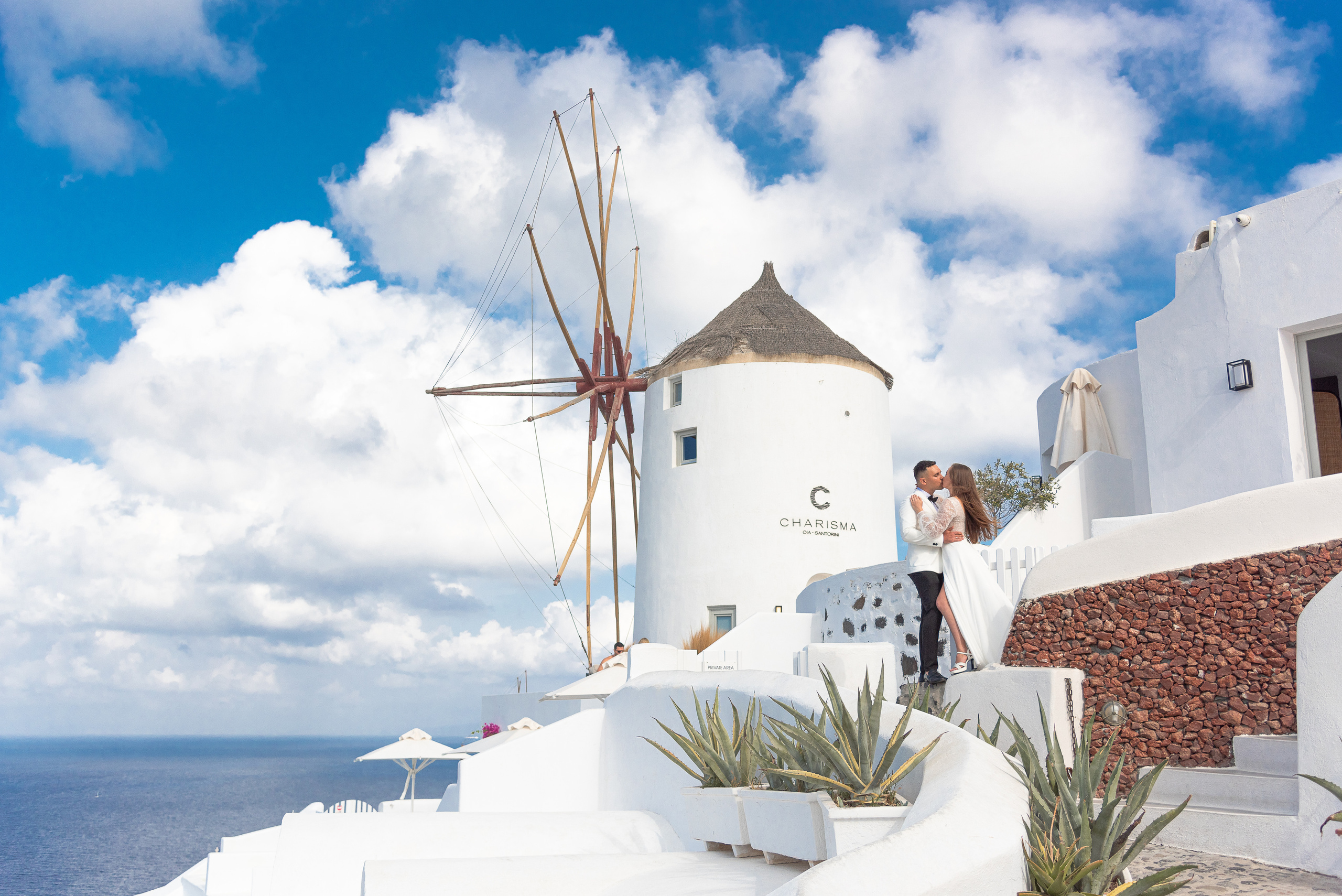 Wedding photo shoot in Santorini on the background of a windmill couple in white