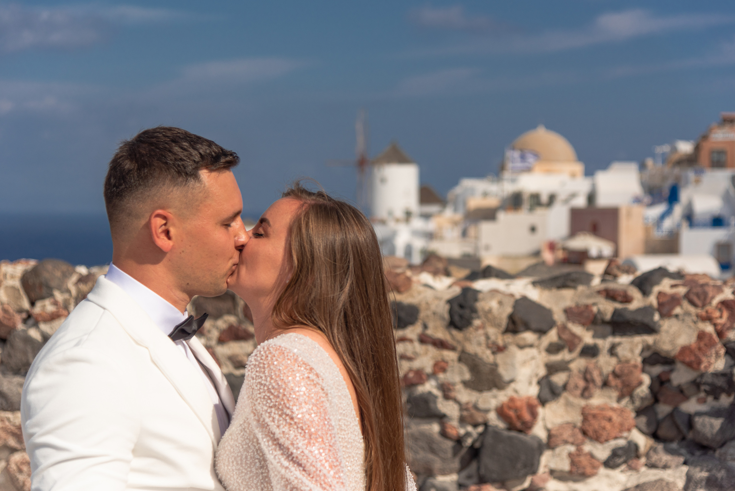 Wedding photo shoot in Santorini on the background of a windmill couple in white