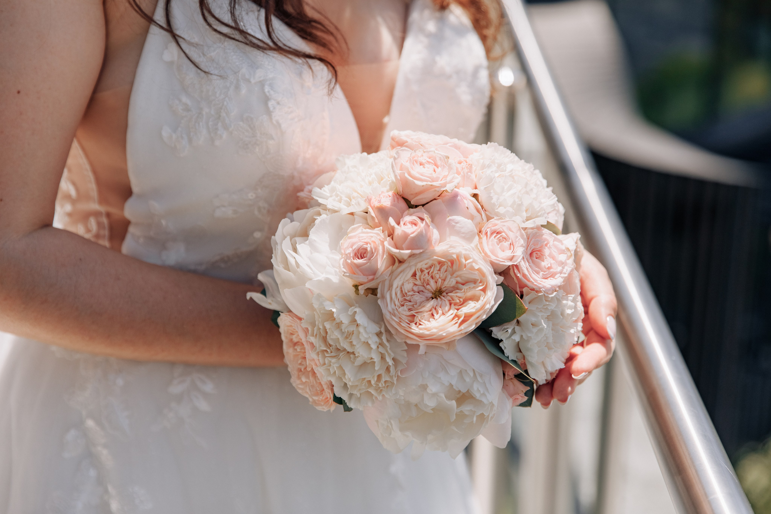 Der Brautstrauß in zarten Rosa- und Pfirsichtönen, ein elegantes und romantisches Detail der Hochzeit.