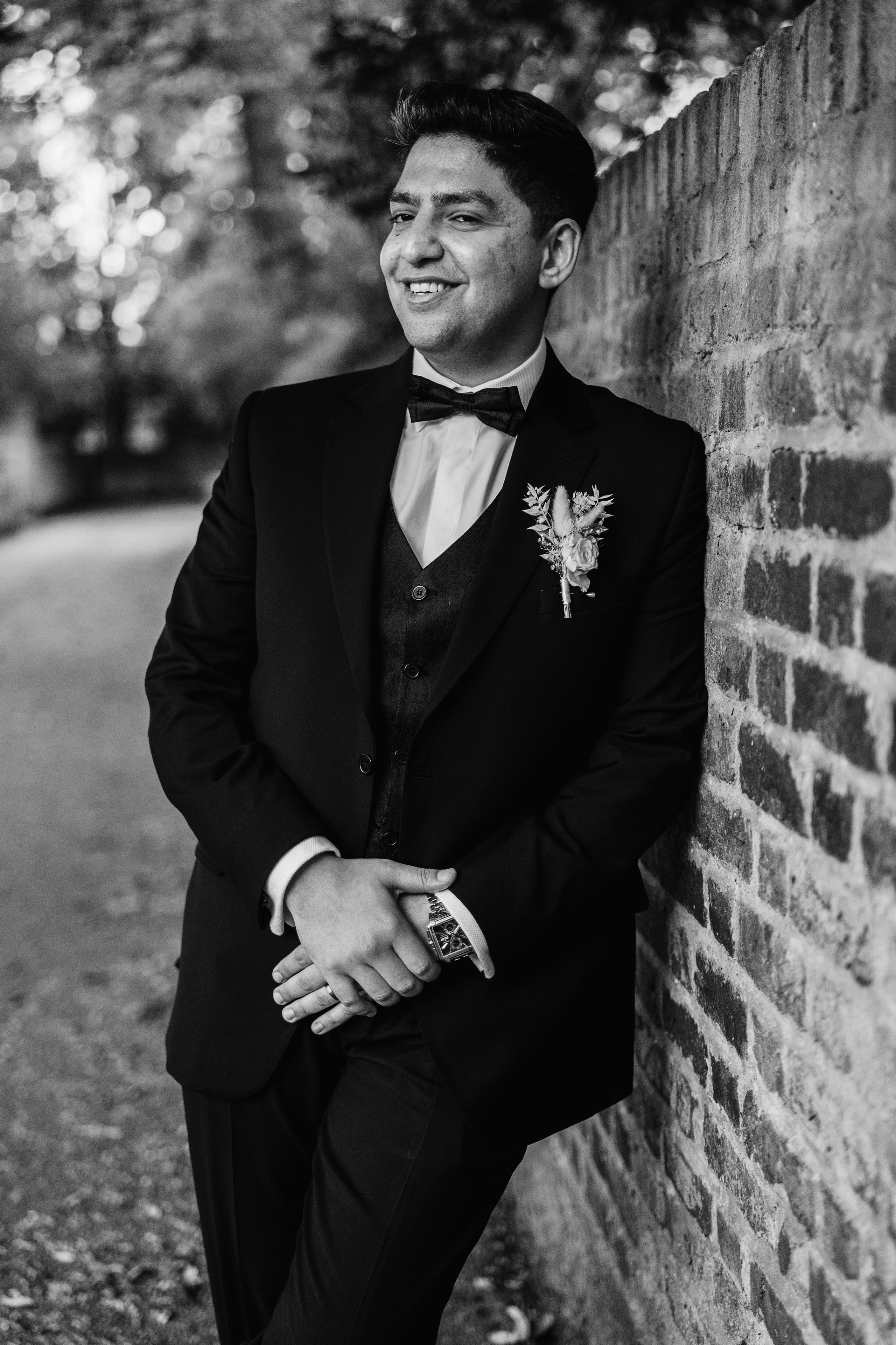 stylish black and white photo of the groom near the wall