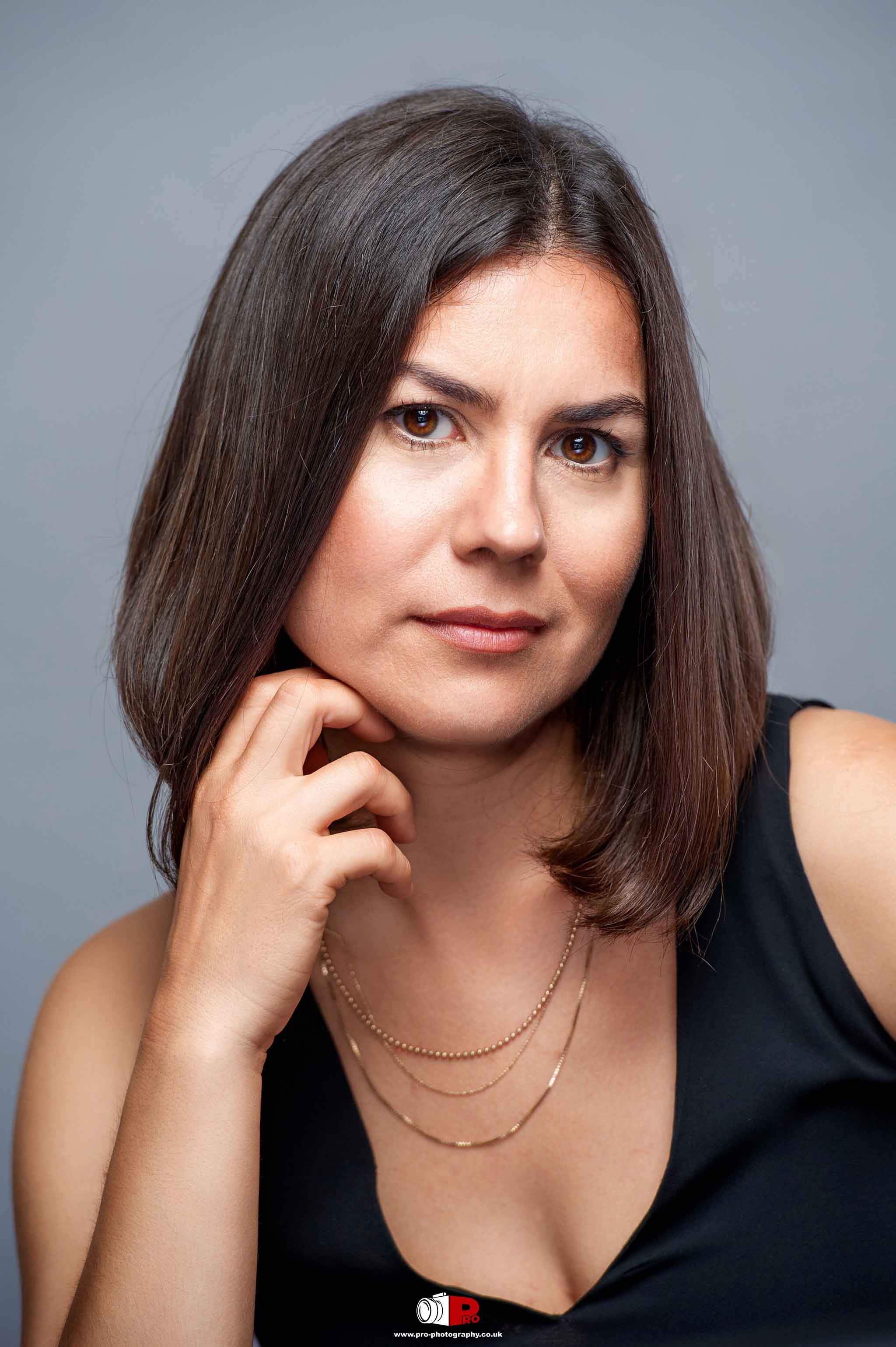 Corporate headshot of a professional woman with brown hair, exuding confidence and elegance.
