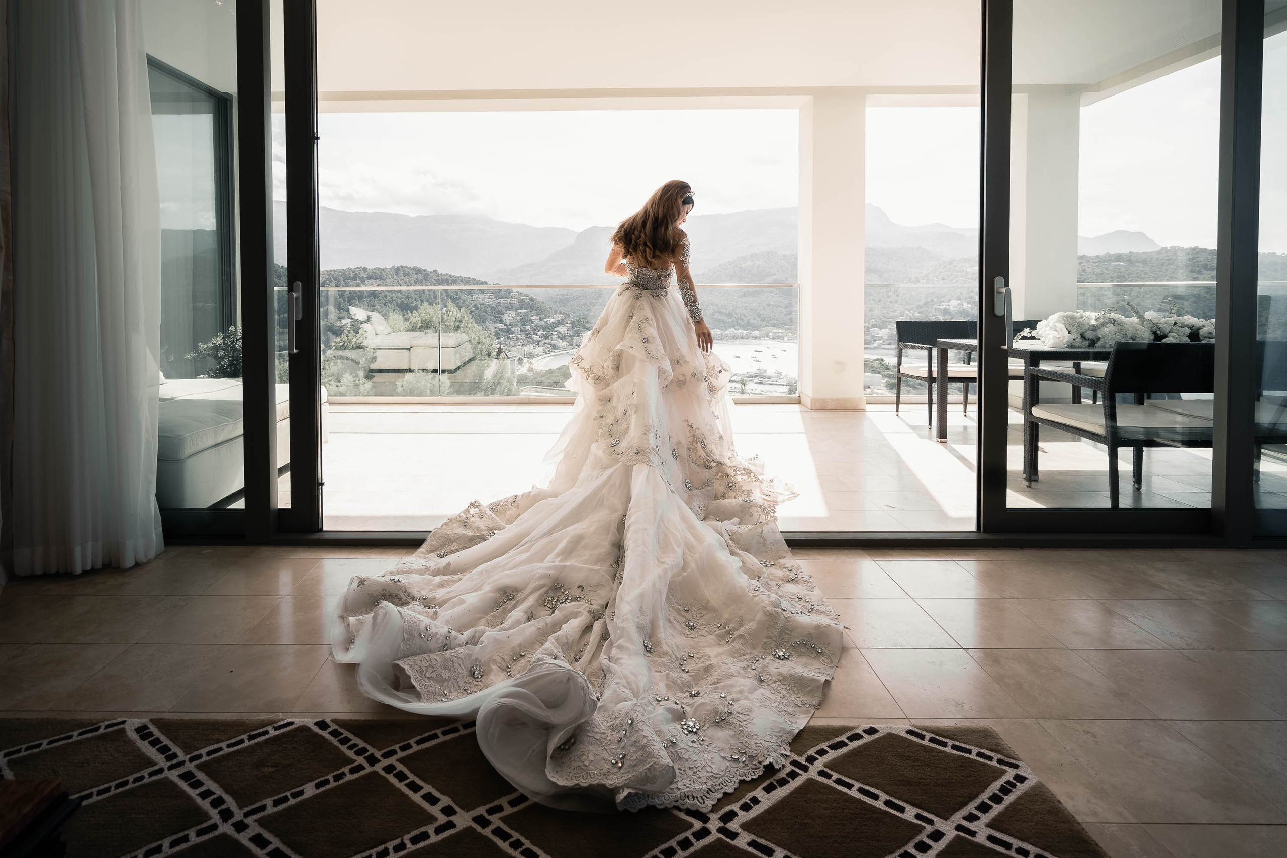 Bride and bridal gown with the Port of Soller as landscape for a Mallorca Destination Wedding