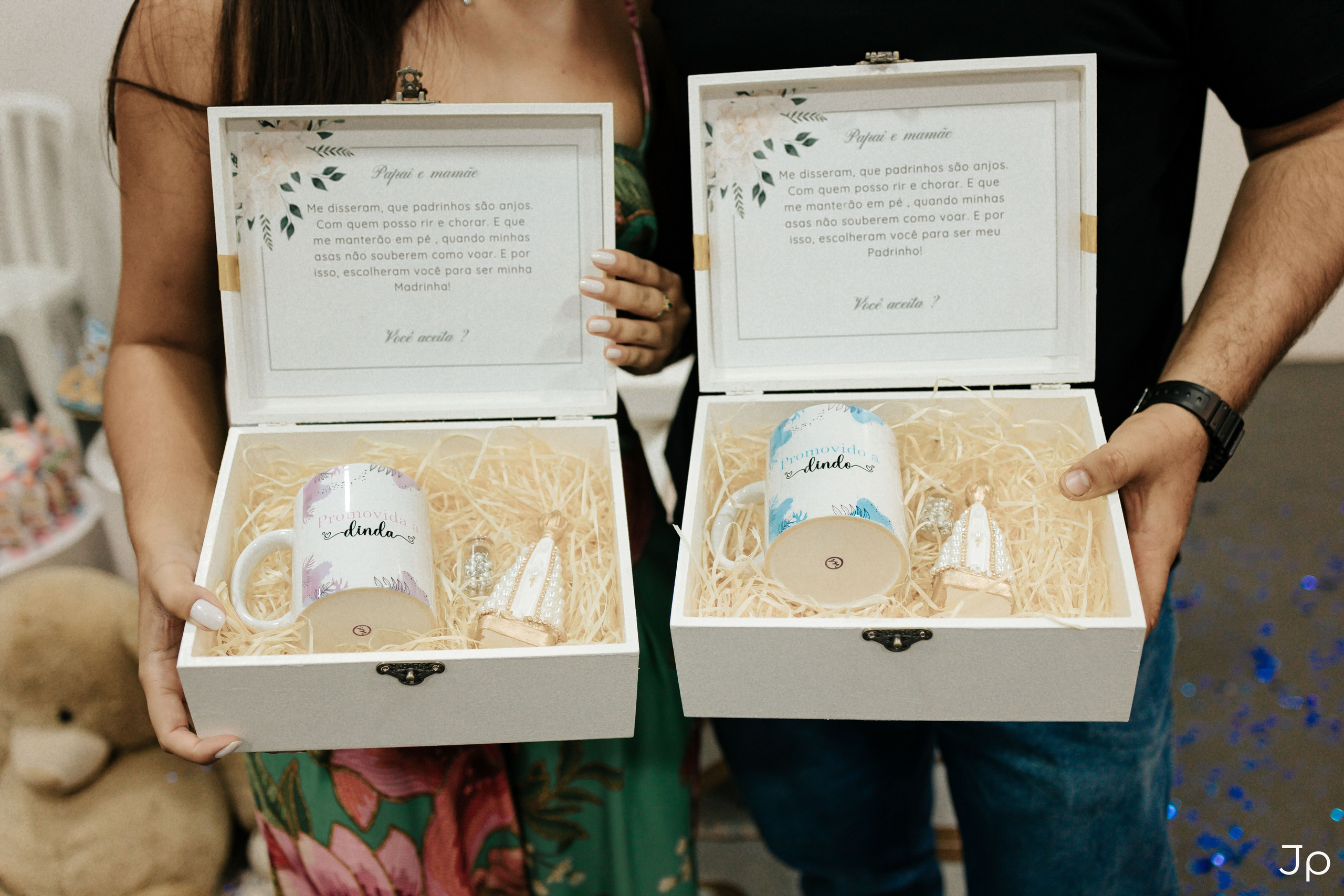 Casal segurando uma caixa de presente contendo duas canecas.