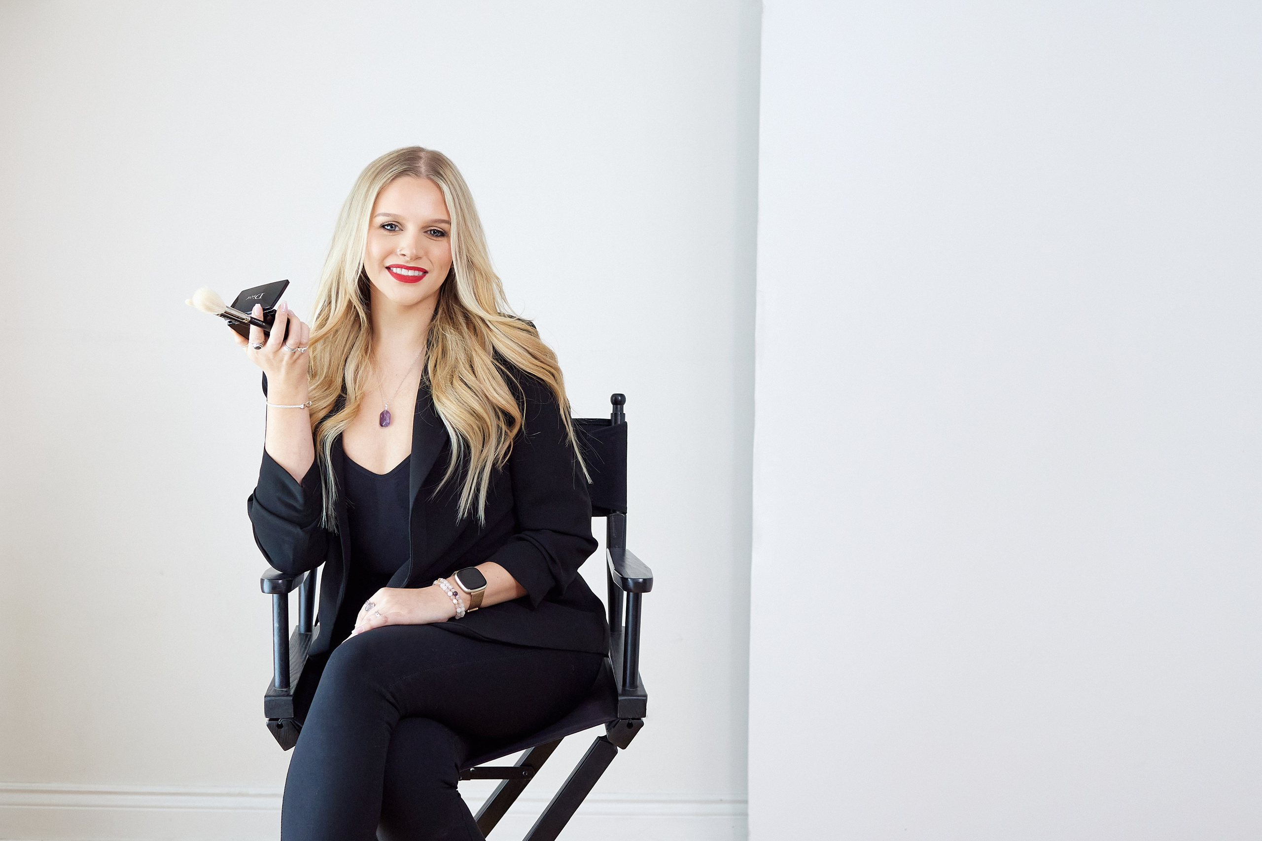 makeup artist sitting in chair holding her makeup tools 