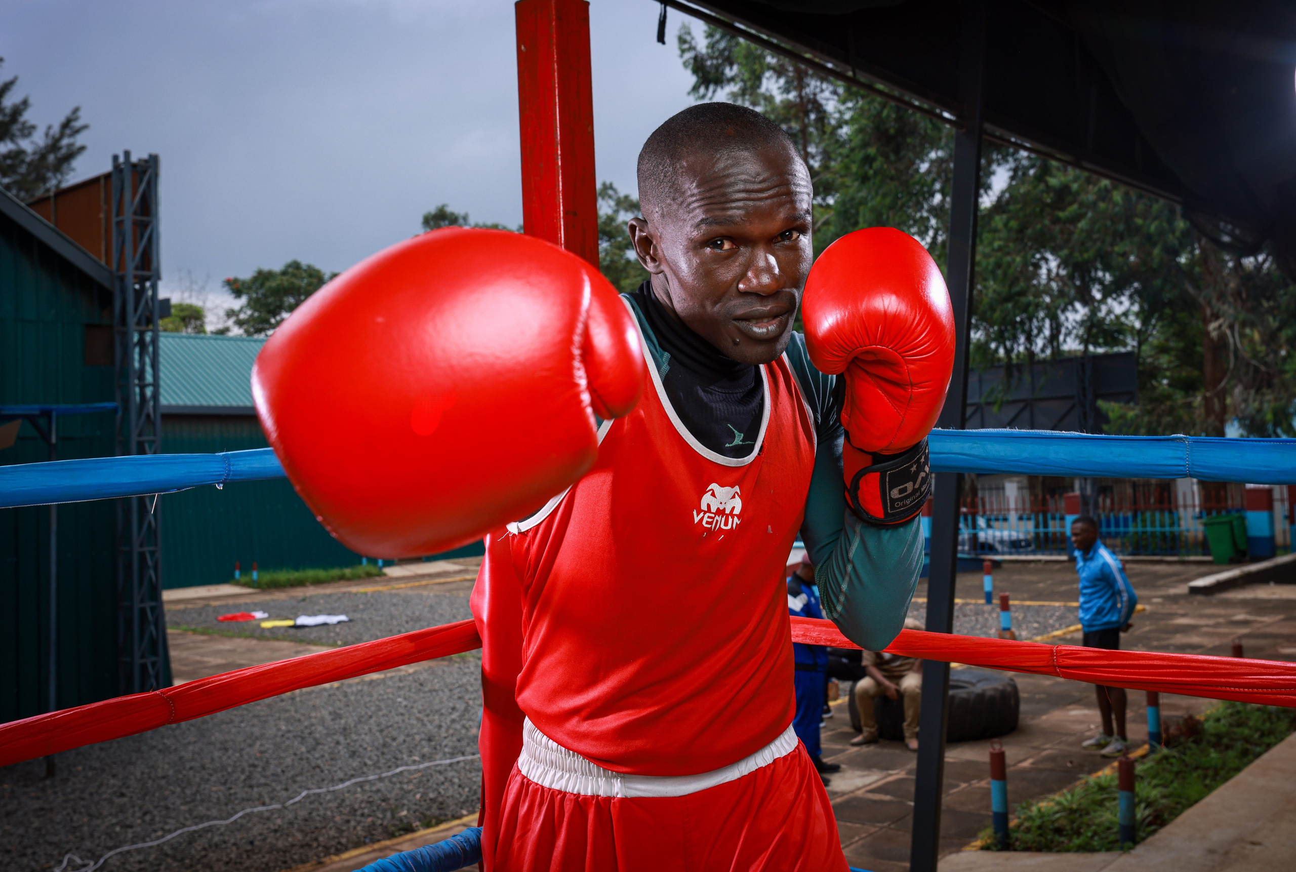 A medium close-up photo of a boxer with his right hand throwing a punch straight to the lens. Documentary photography