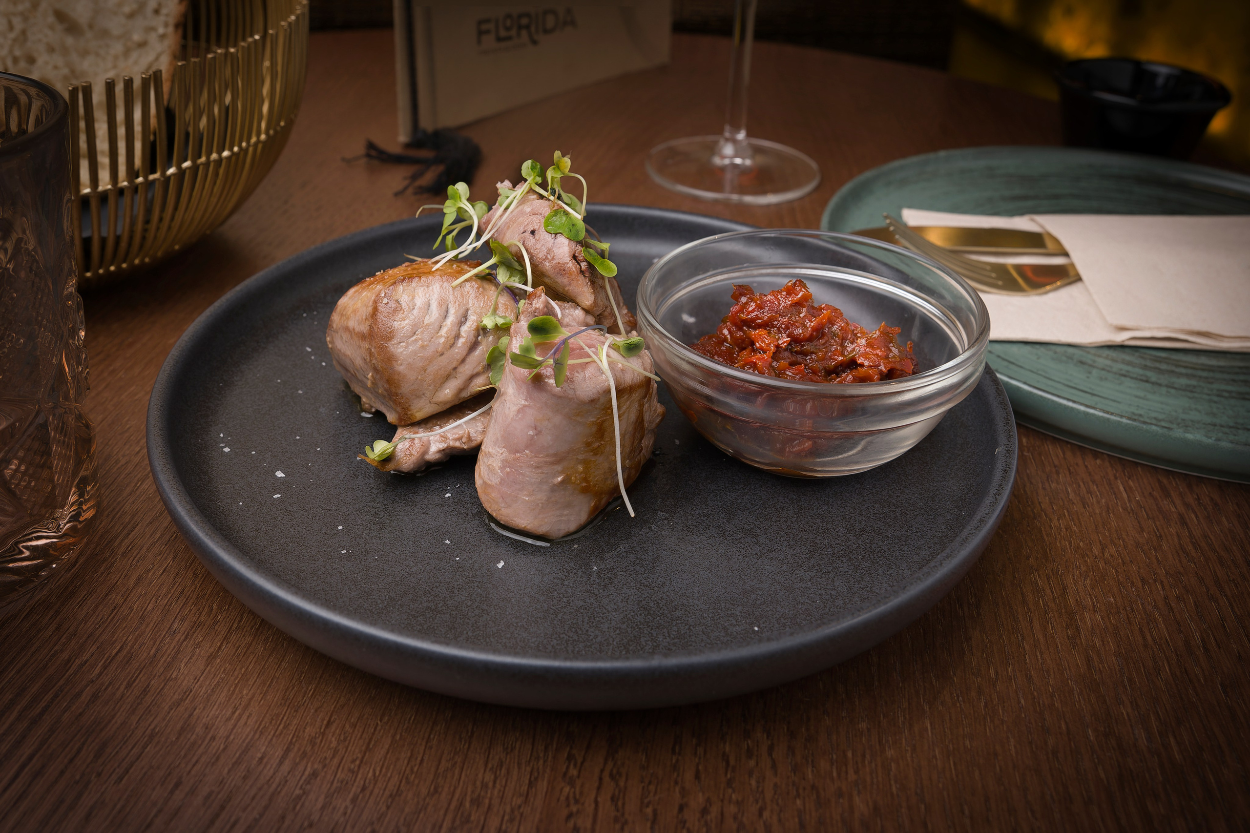 Imagen de comida cuidadosamente emplatada sobre fondo oscuro, capturando detalles y contraste visual.