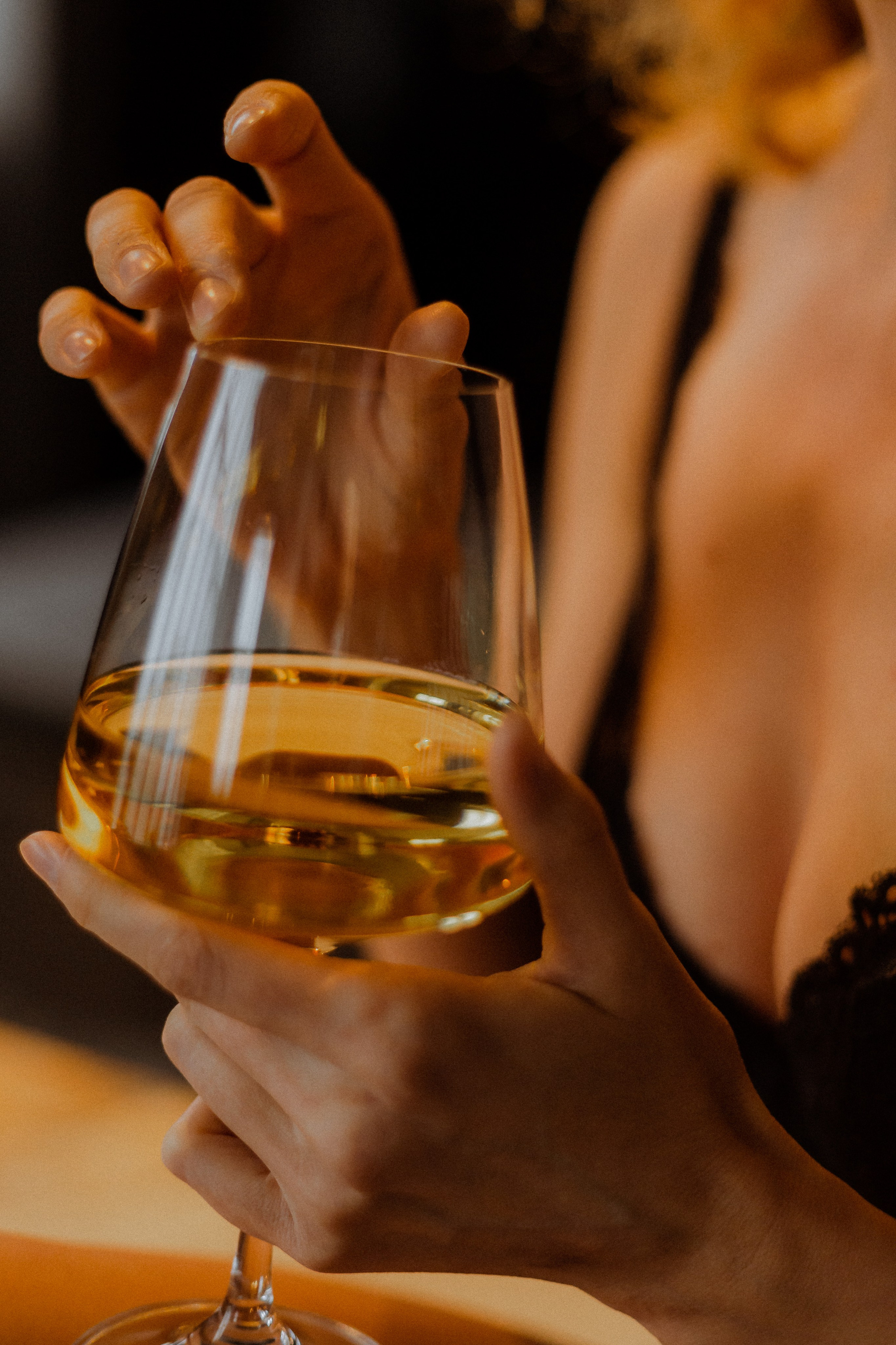 Foto sexy de la mano de una chica con una copa de vino
