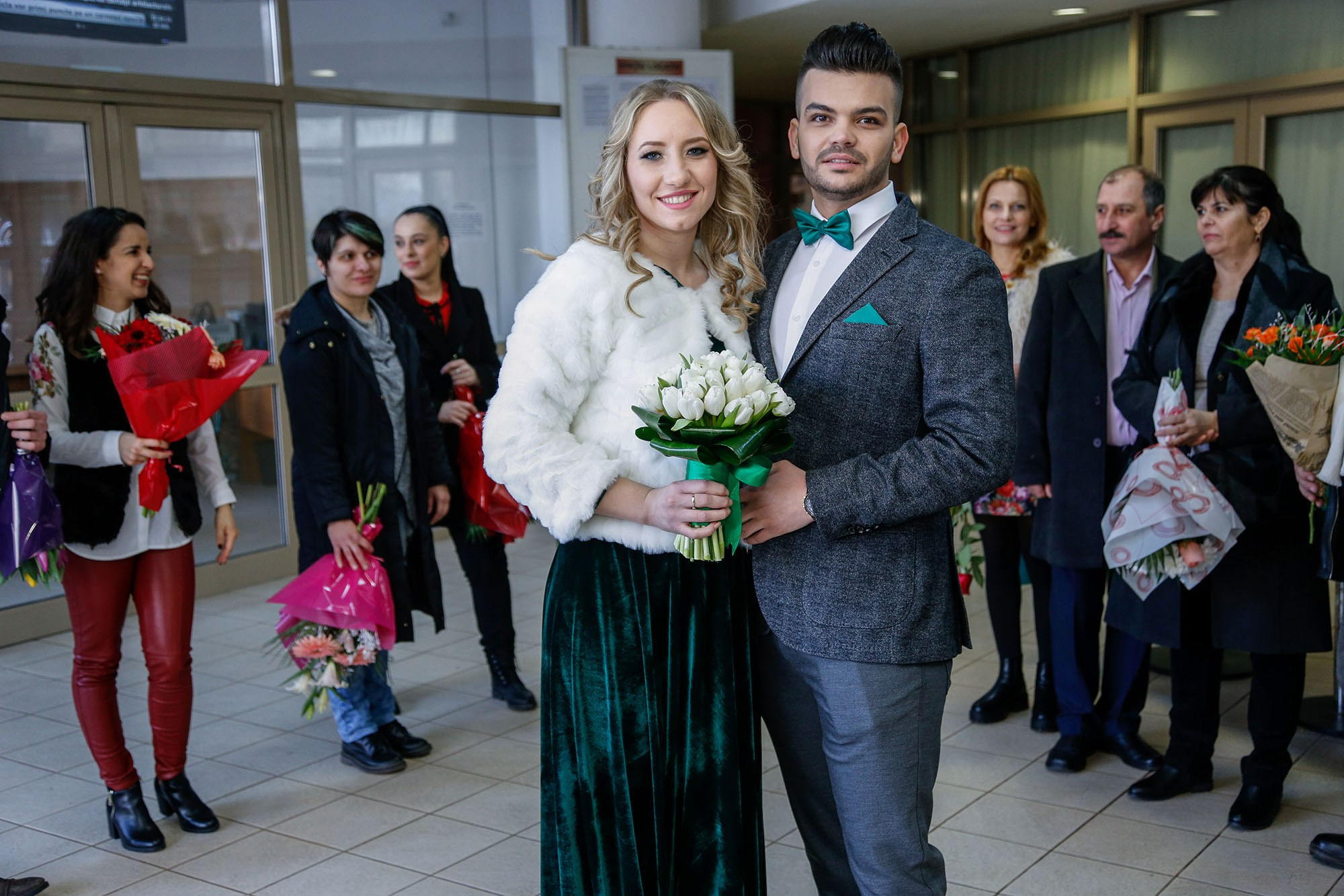 Smiling newlyweds posing in the elegant hallway of the town hall during a professional civil ceremony photo shoot.