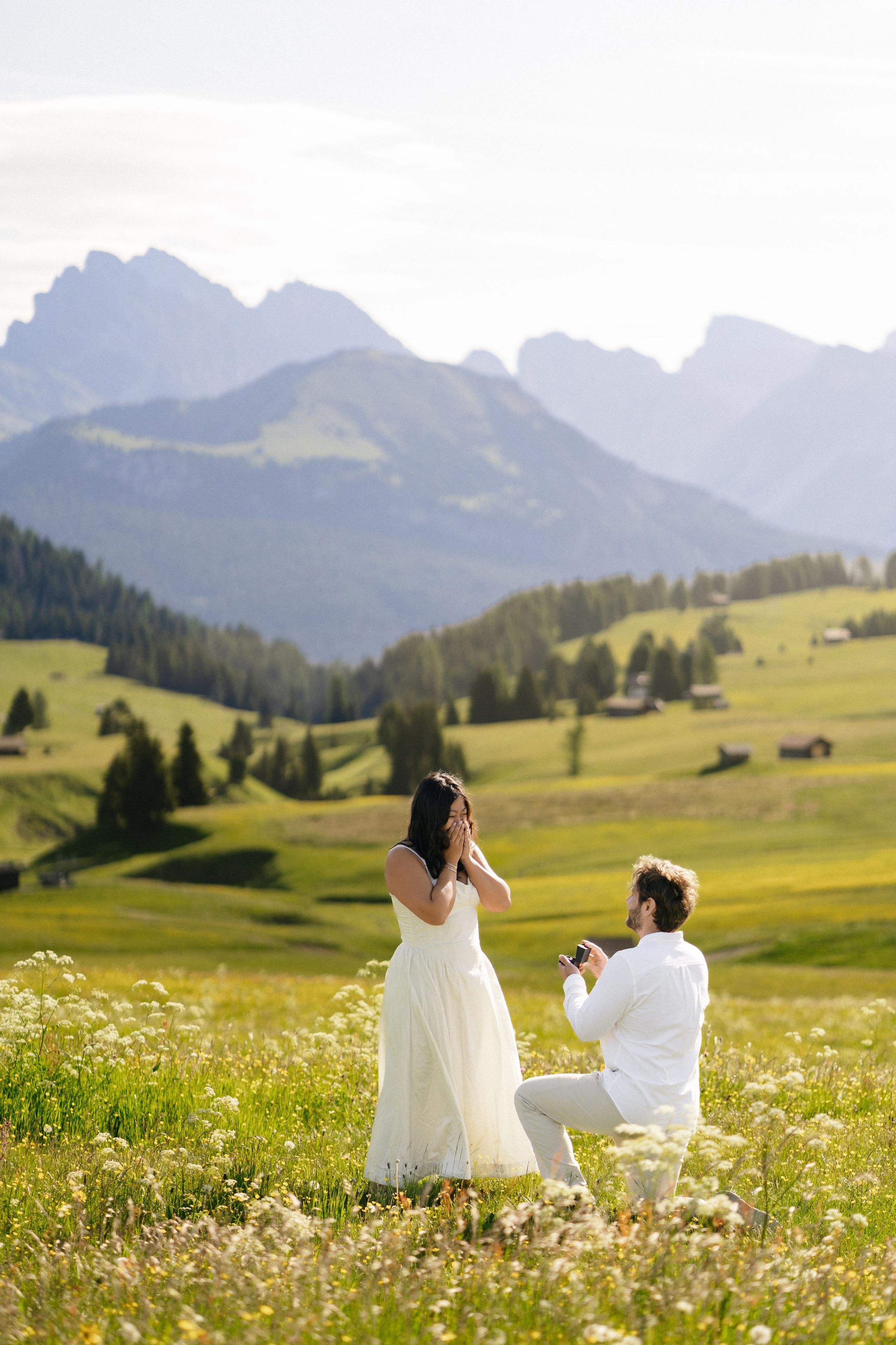 Man proposing to his partner with the mountains of Alpe di Siusi in the background.
