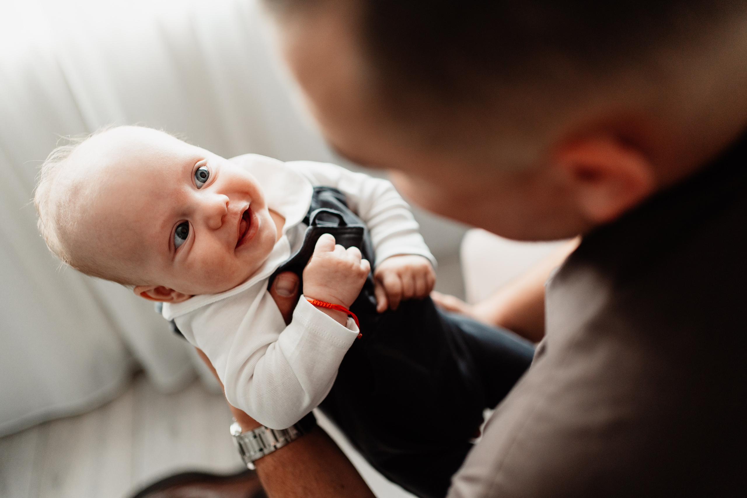 Instantaneu plin de tandrețe dintre părinți și bebeluș în ziua botezului, realizat în Craiova. Fotografie profesională de botez, capturând emoțiile autentice ale familiei într-un decor luminos și cald