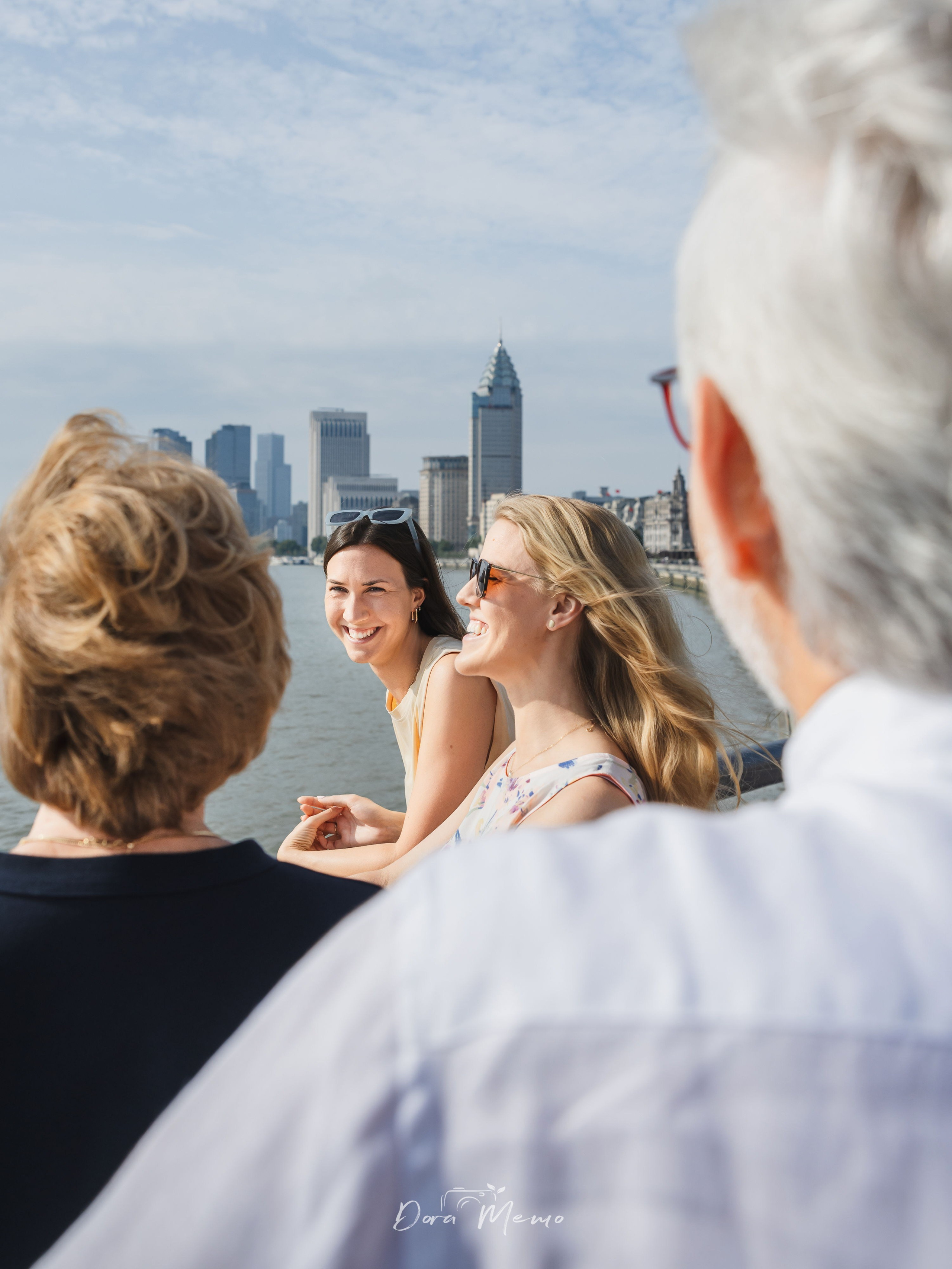 A father and his daughters standing by the river in Shanghai during a farewell family session.