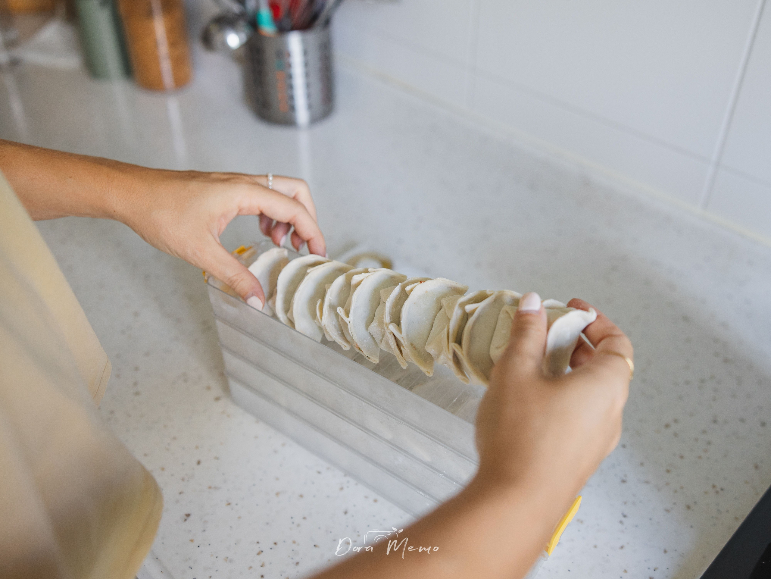 Hands placing homemade dumplings in a Shanghai family home.