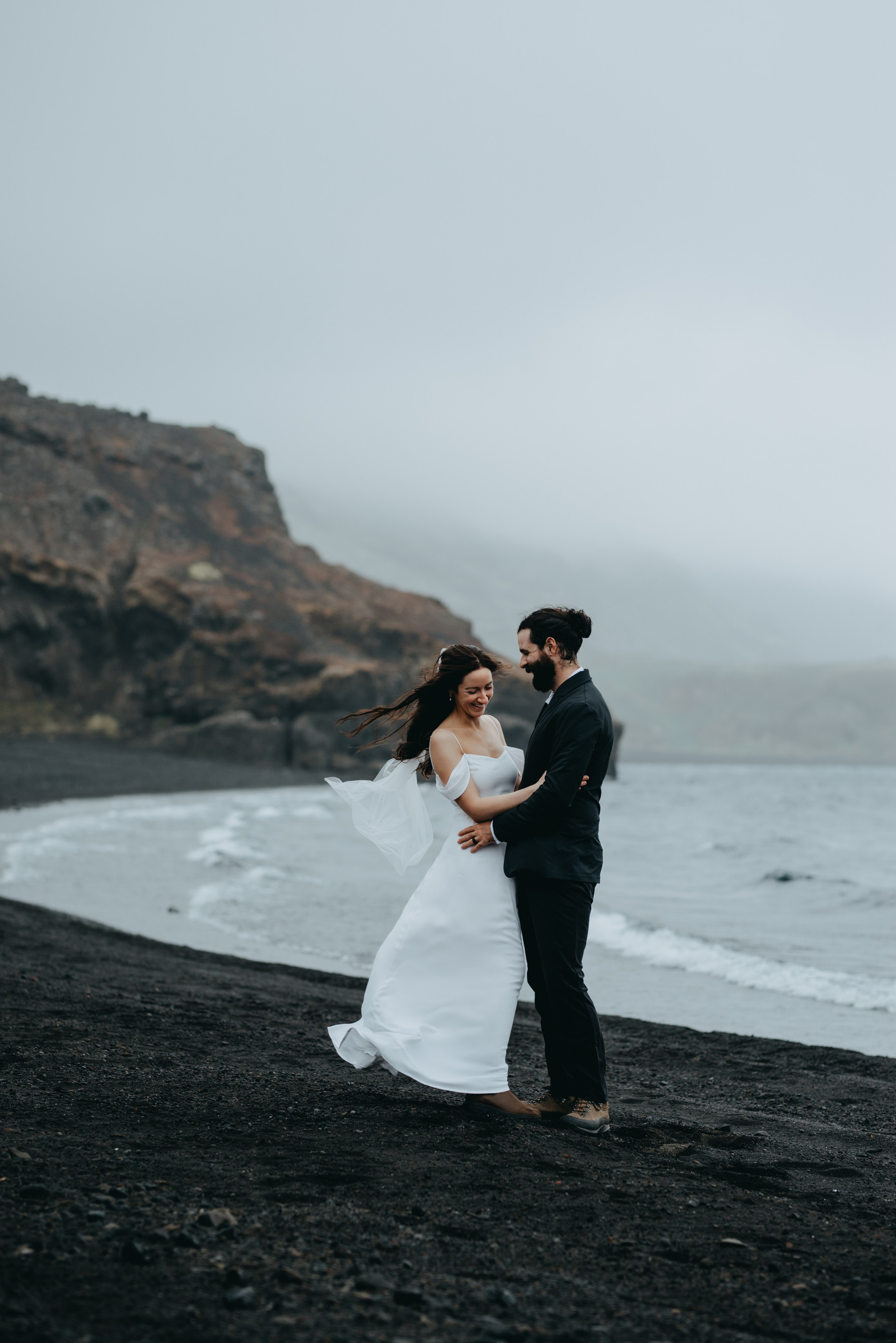 Romantic moment between bride and groom in Krýsuvík, with dramatic volcanic hills in the background.