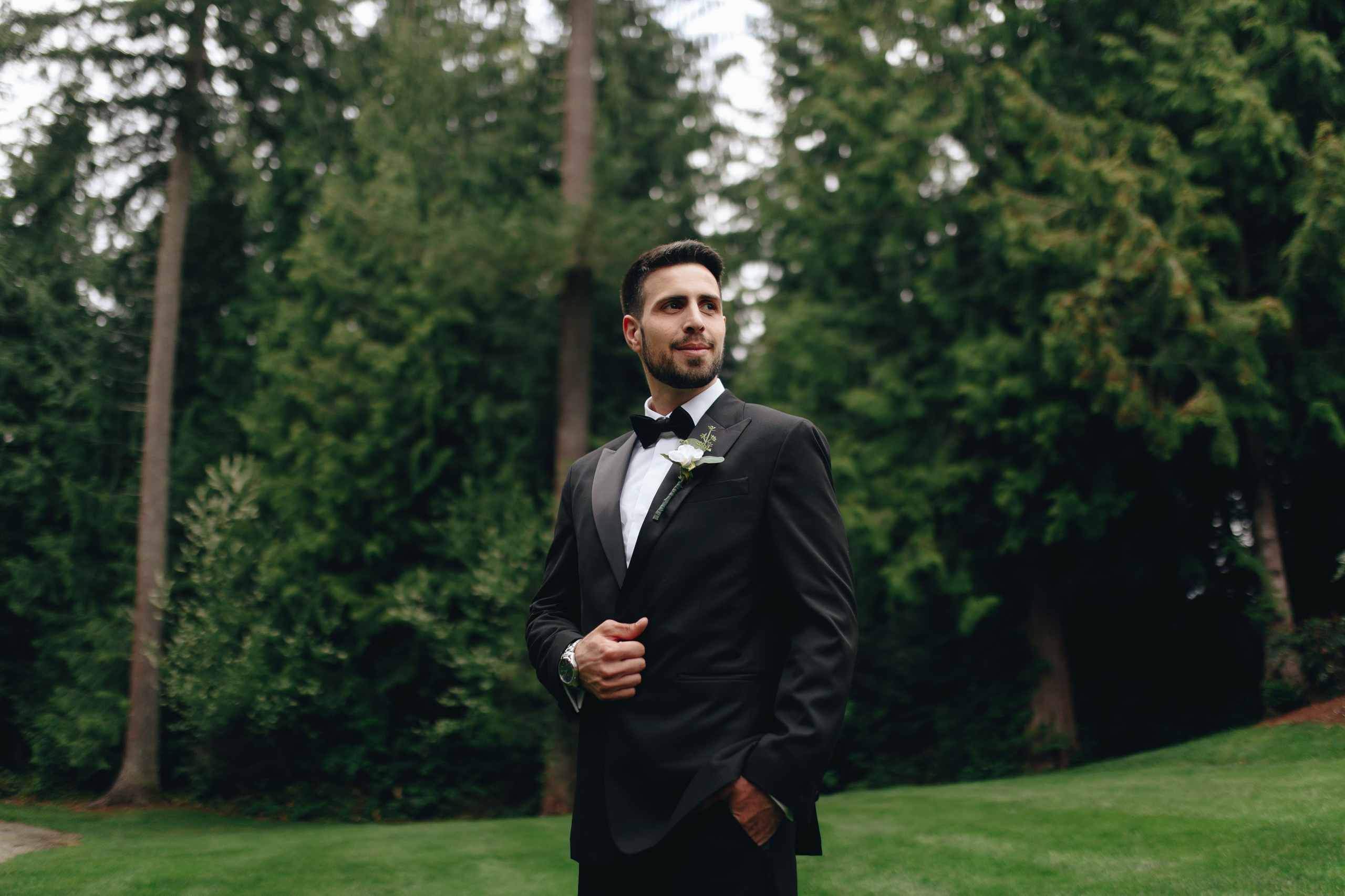 Groom standing on green lawn, classic wedding portrait