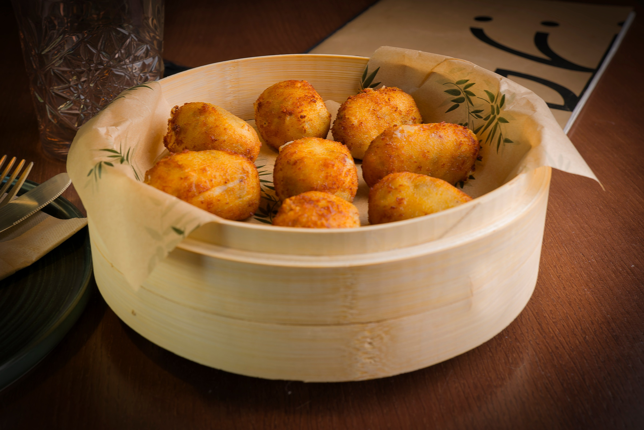 Imagen de comida cuidadosamente emplatada sobre fondo oscuro, capturando detalles y contraste visual.