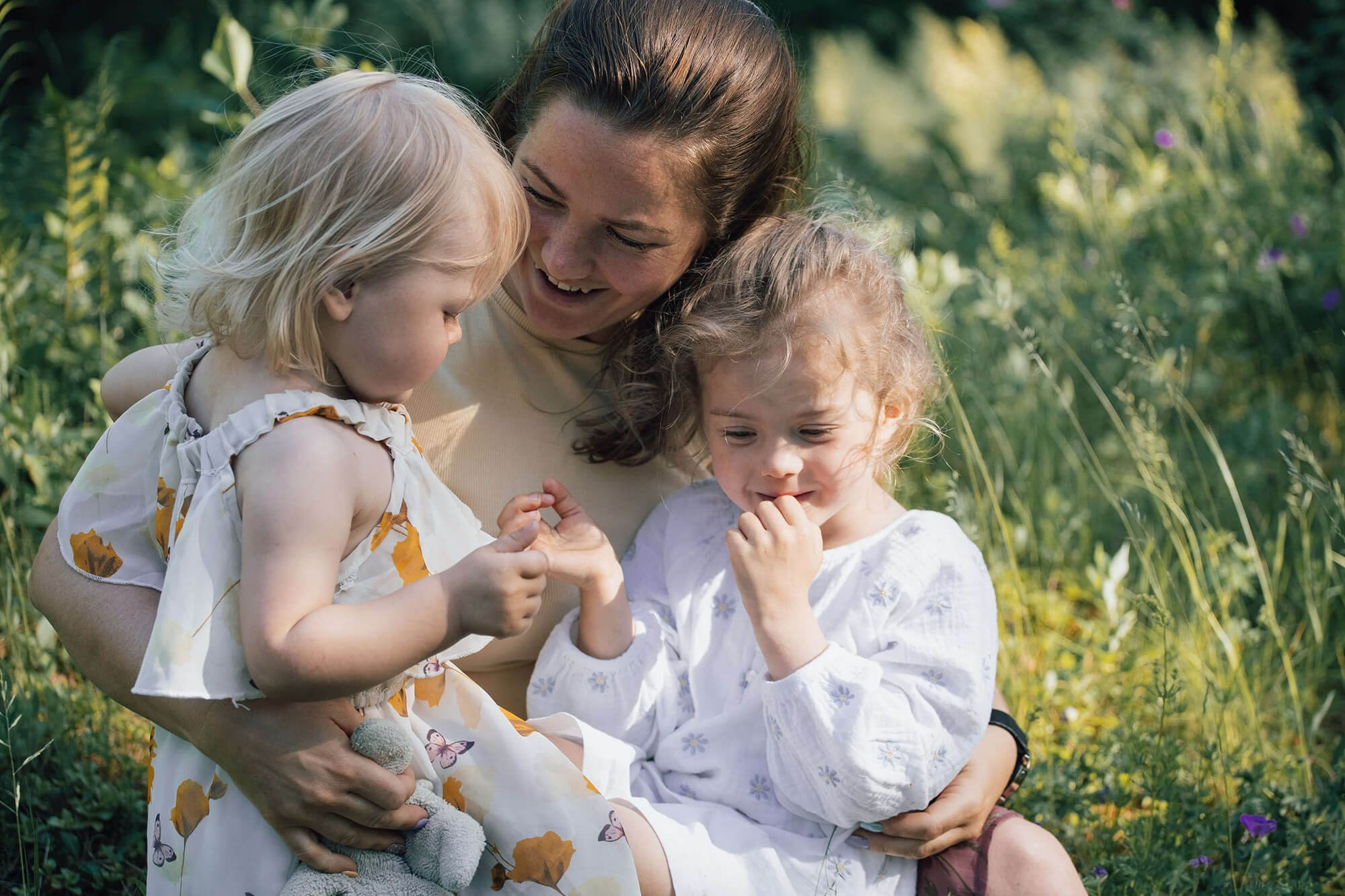 Familie smiler og klemmer hverandre foran kameraet