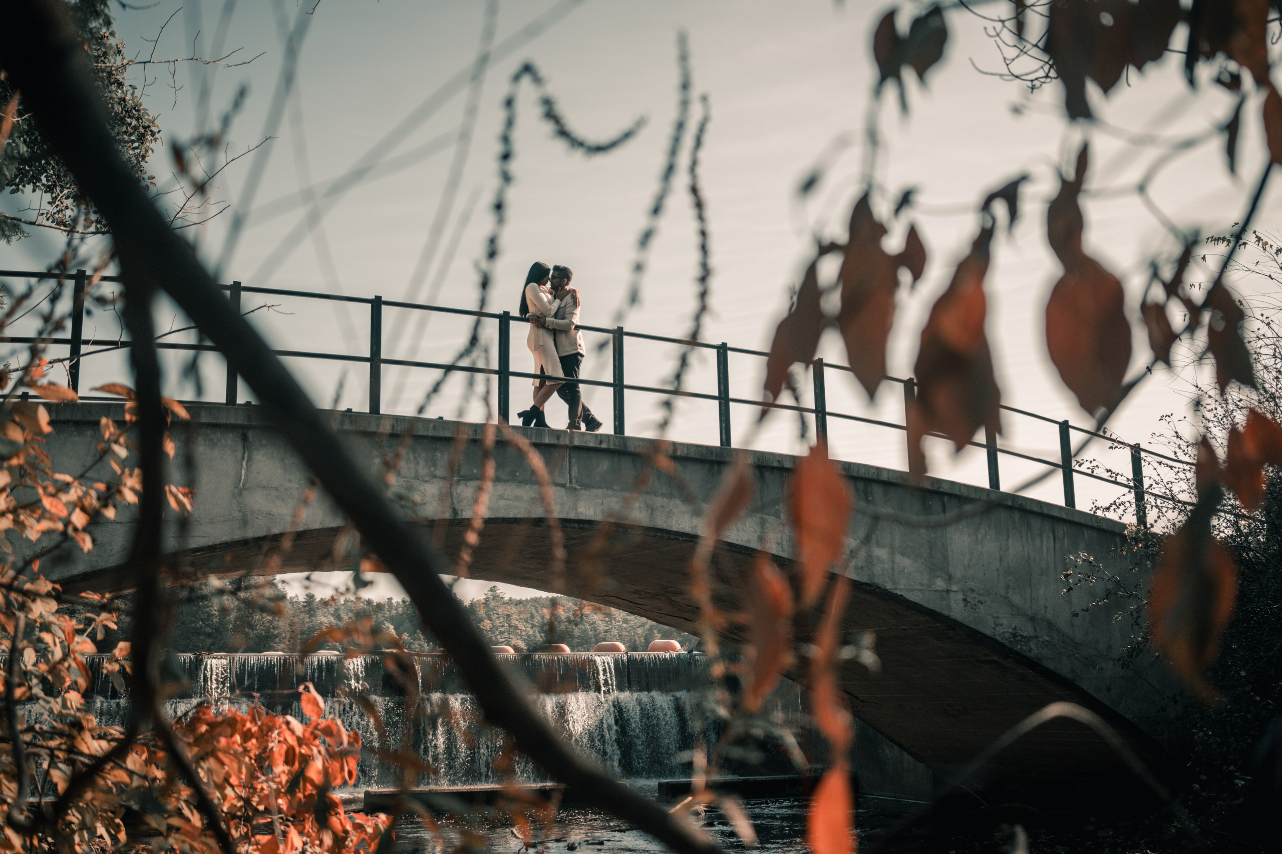 Couple walking through a golden autumn park, capturing their engagement moments