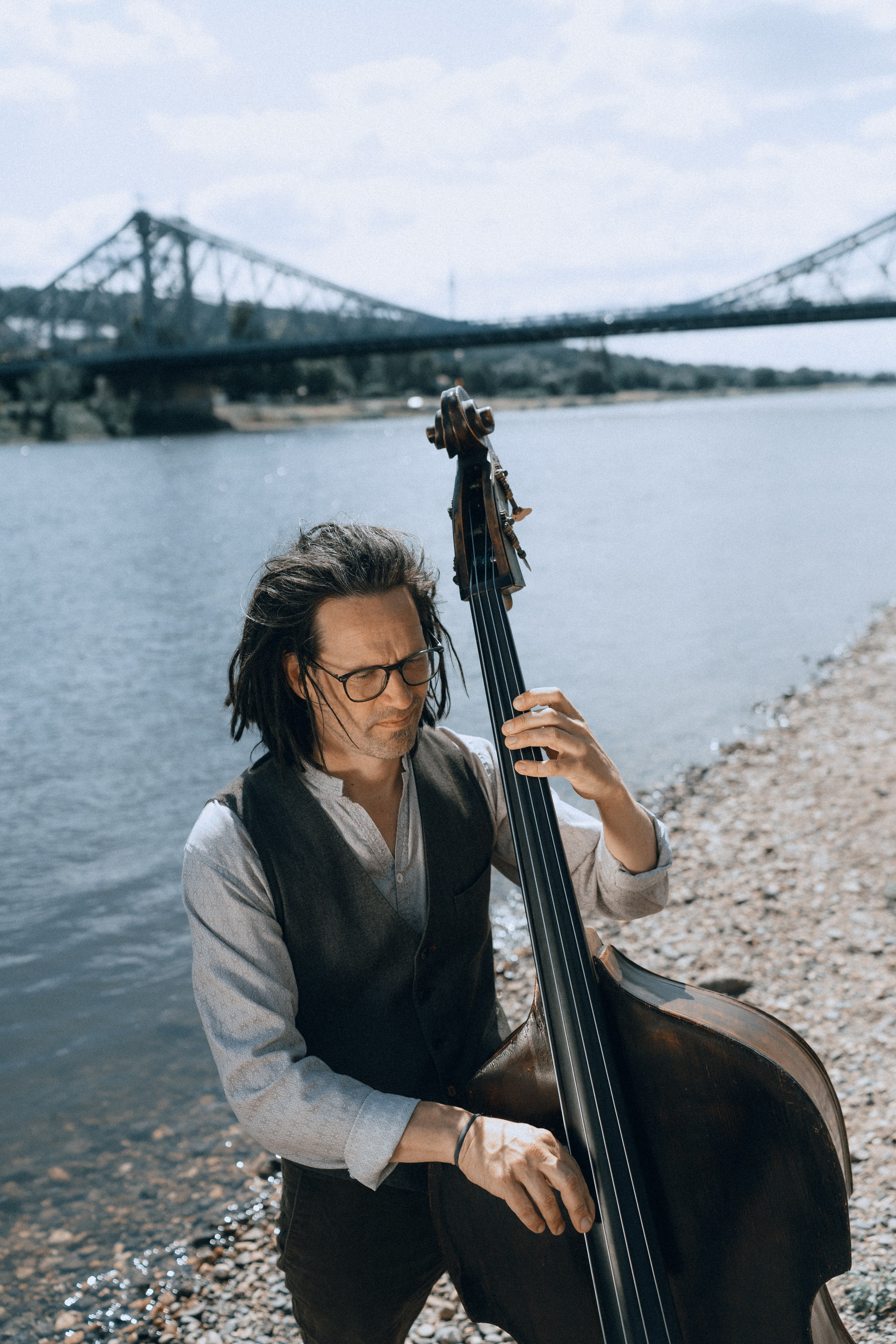 Kontrabassist am Ufer der Elbe, Sommerlicht