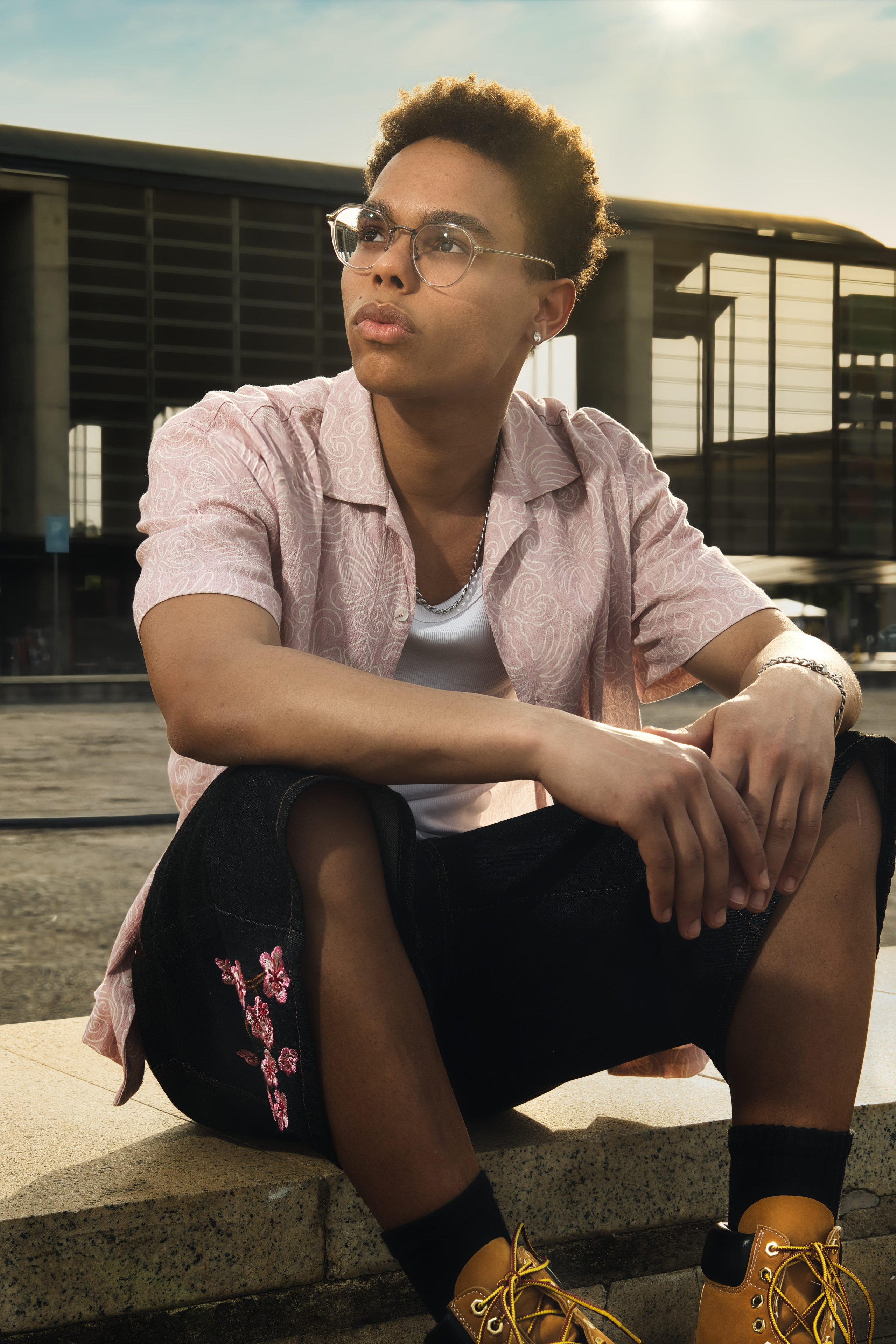 Hombre joven posa con una expresión reflexiva luciendo un look de moda urbana.