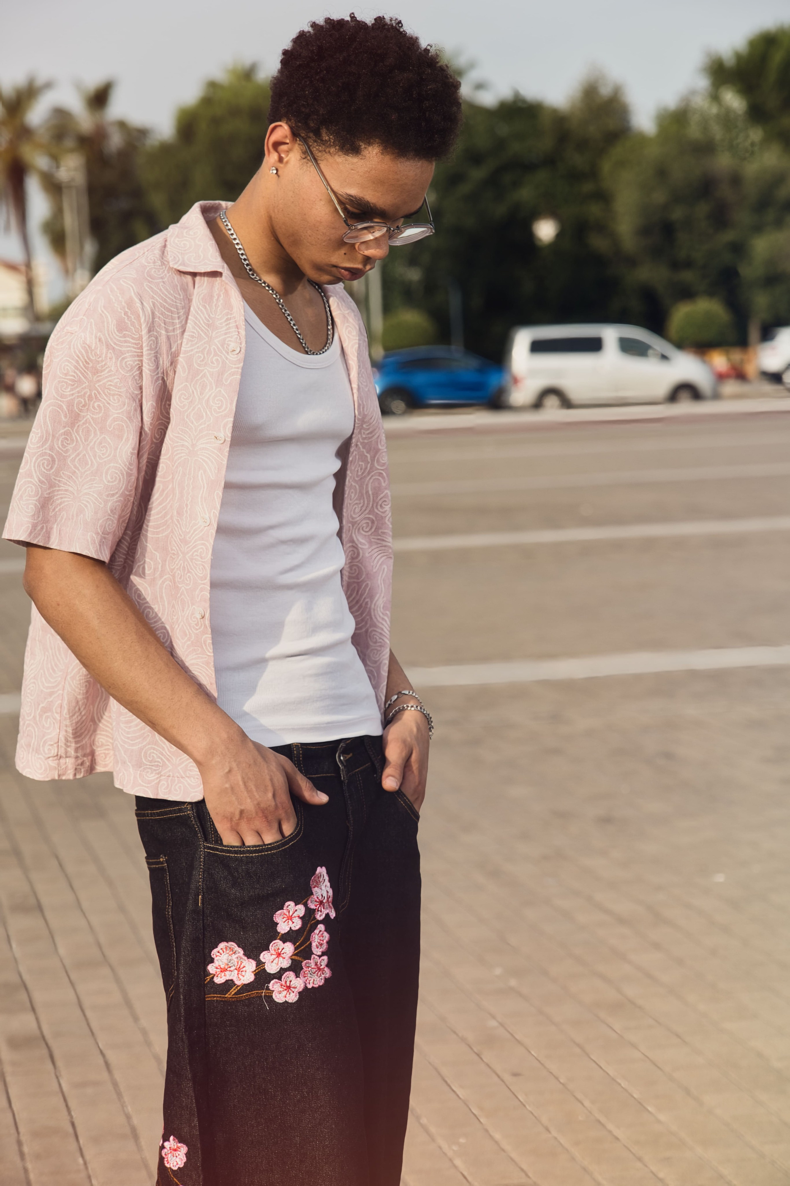 Look completo de streetwear para hombre con botas, shorts bordados y camisa estampada.