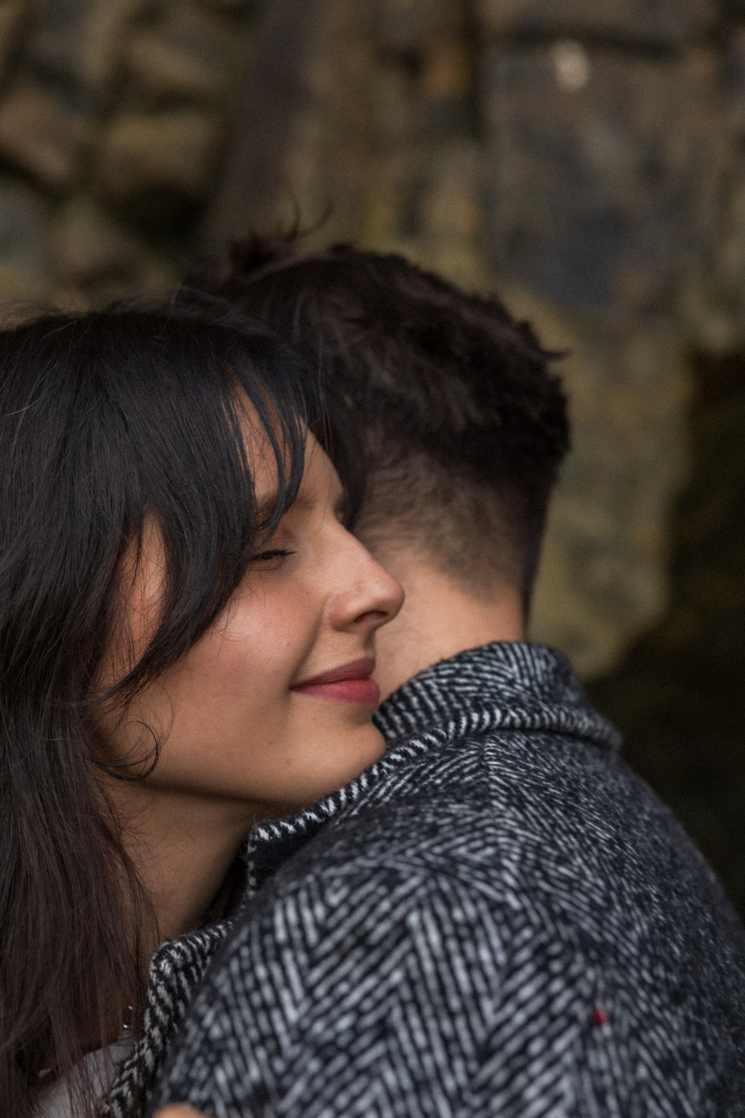 Couple holding hands and walking through a picturesque coastline in Portugal.