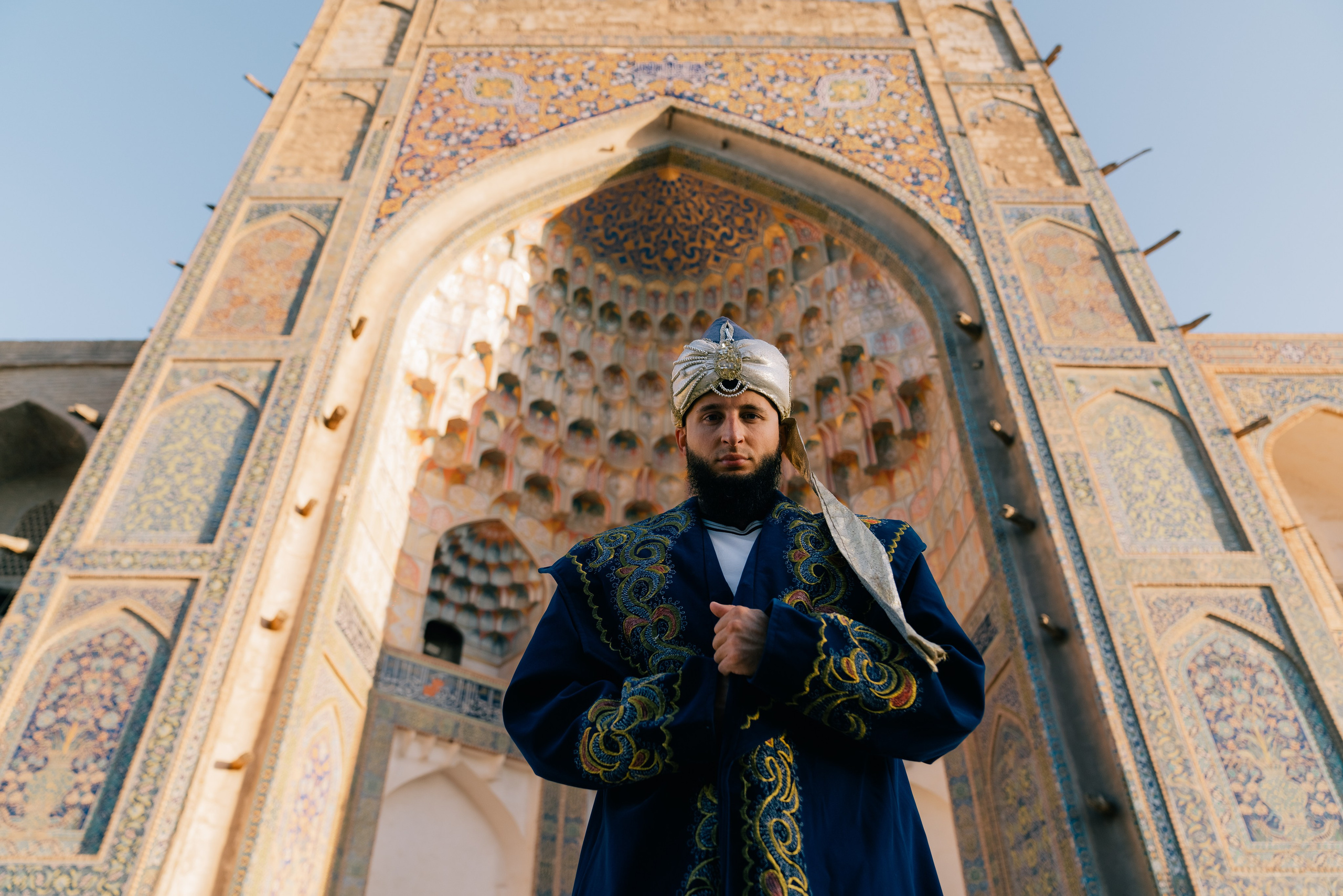 Man in ethnic attire near ancient buildings in Bukhara