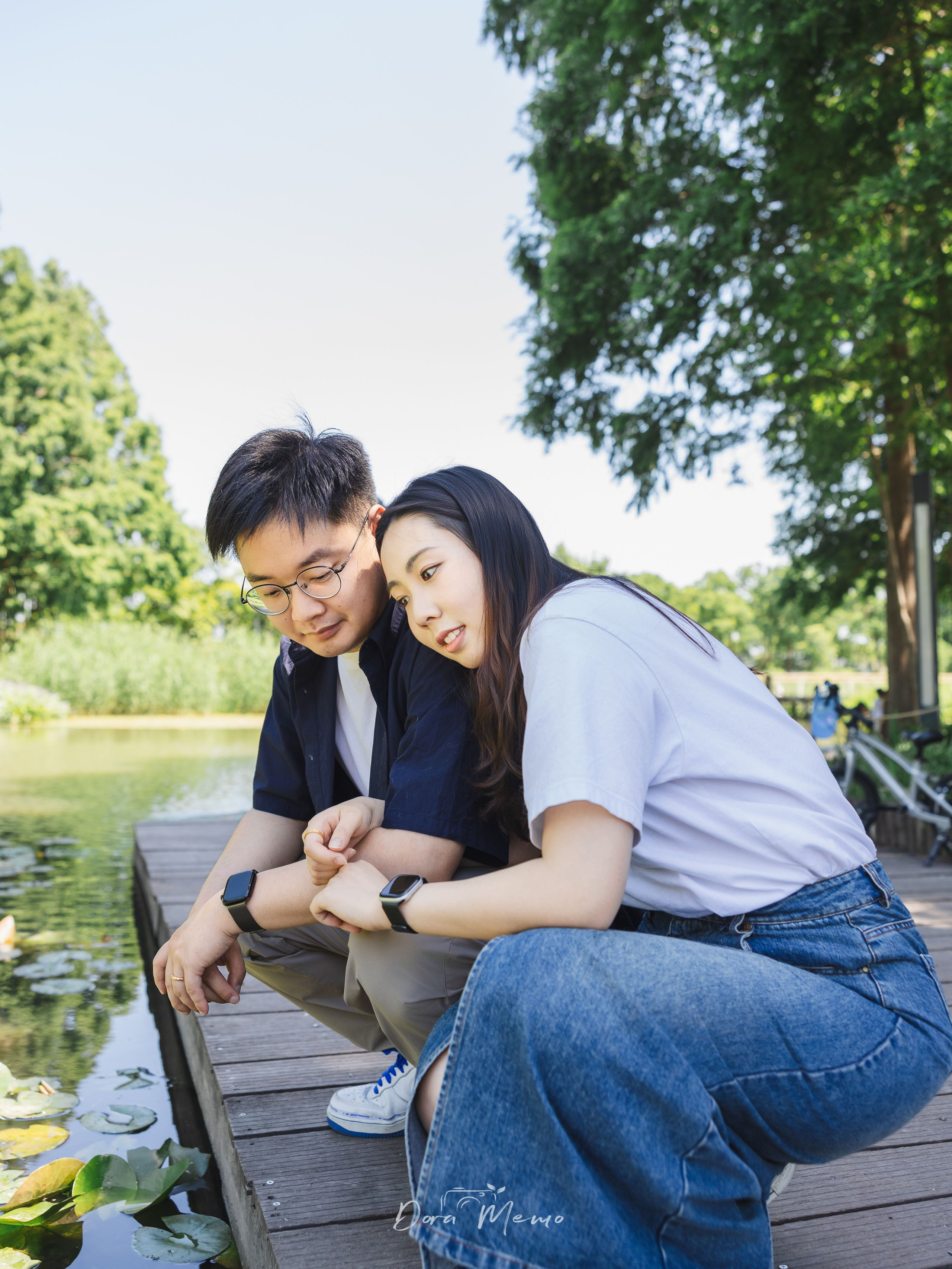 Couple leaning together on a dock gazing at the water, quiet intimate moment