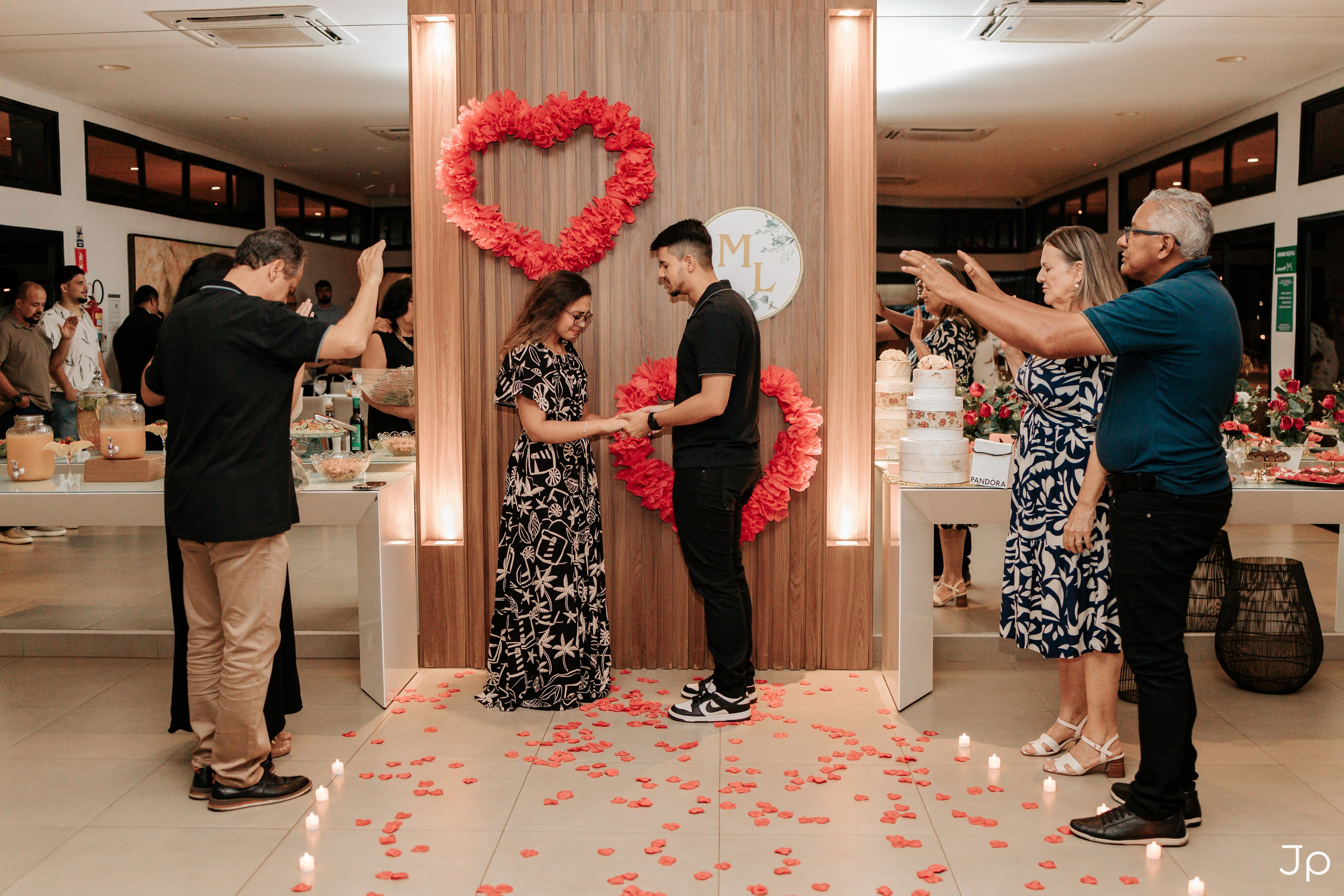 Casal de mãos dadas durante o pedido de noivado.