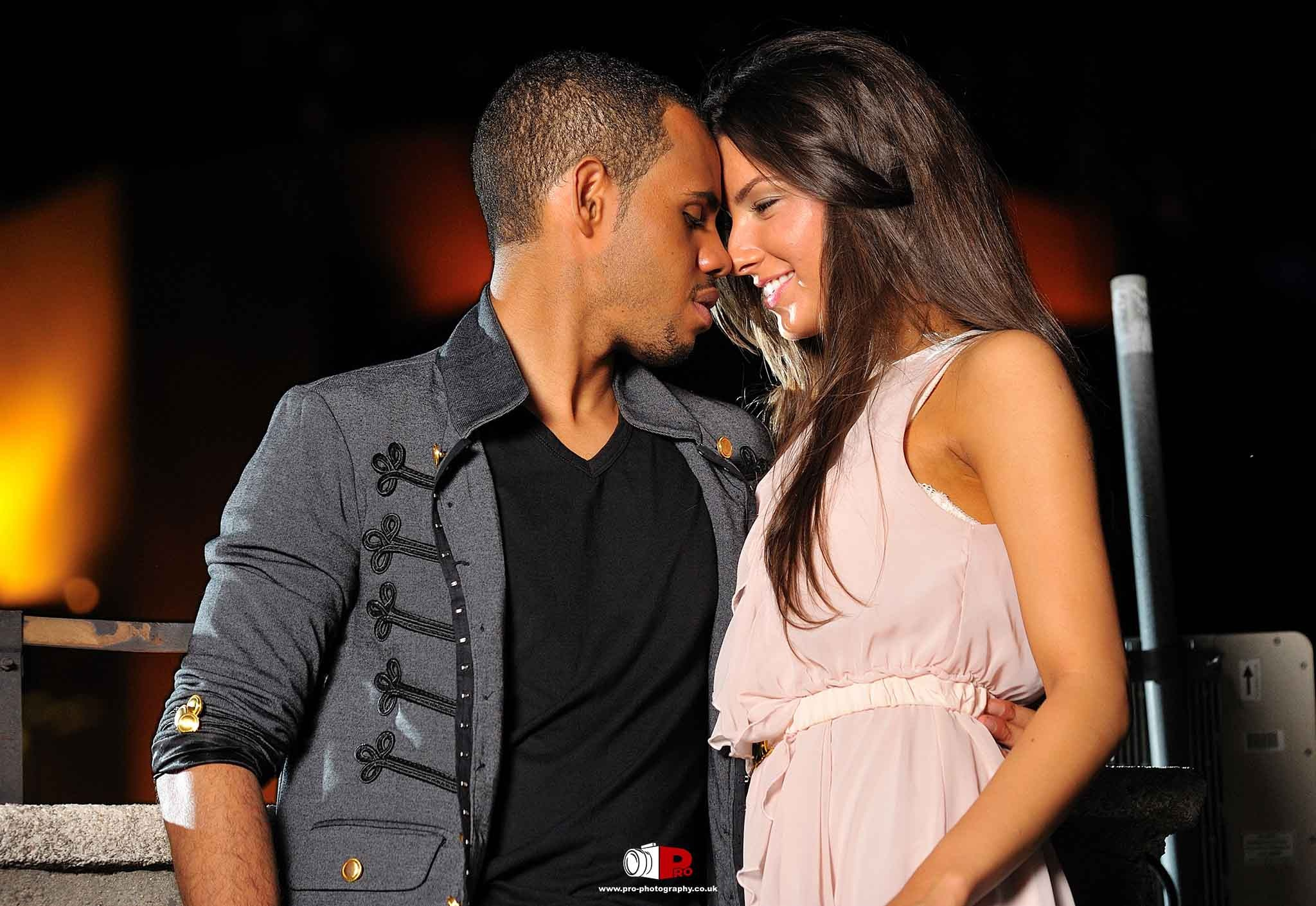 A romantic couple embracing warmly under city lights in a cosy nighttime setting.